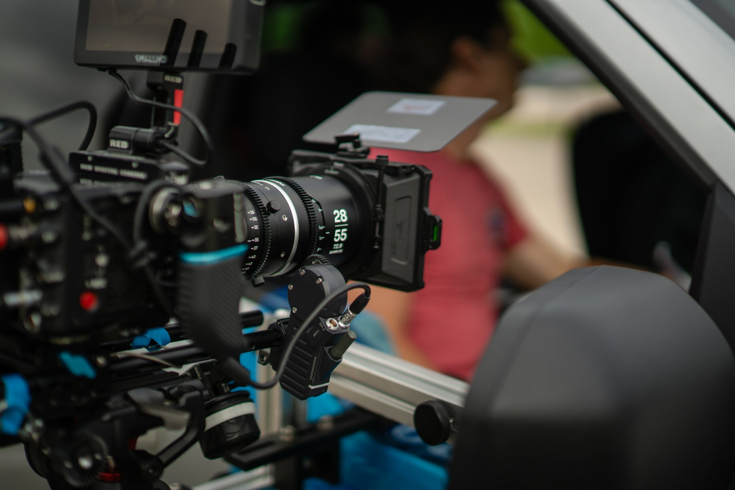 Camera mounted inside a vehicle, focused on the dashboard area, with a person blurred in the background.