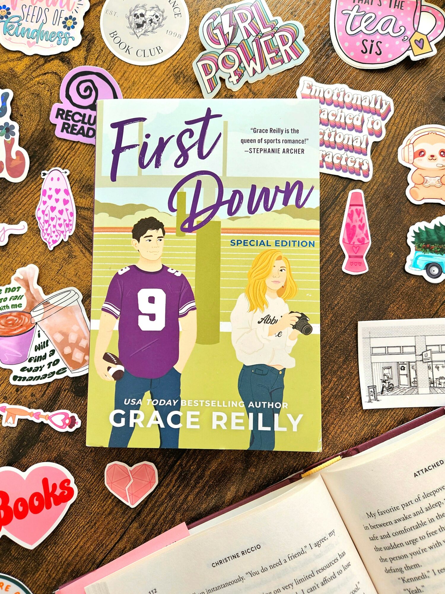 Book titled 'First Down' by Grace Reilly with illustrated girl and boy on cover, surrounded by colorful stickers.
