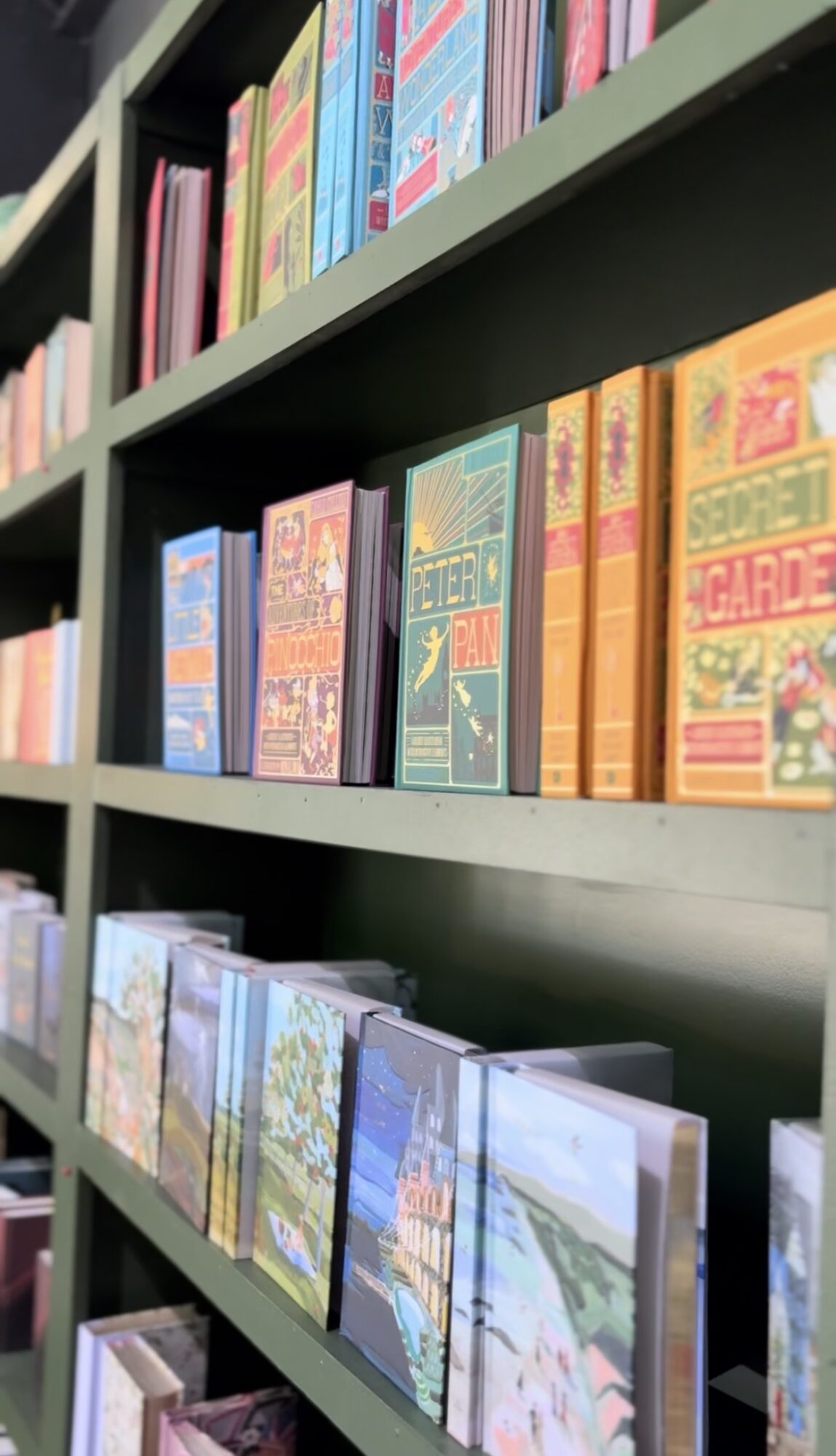 Bookshelves filled with colorful books arranged vertically on multiple shelves.