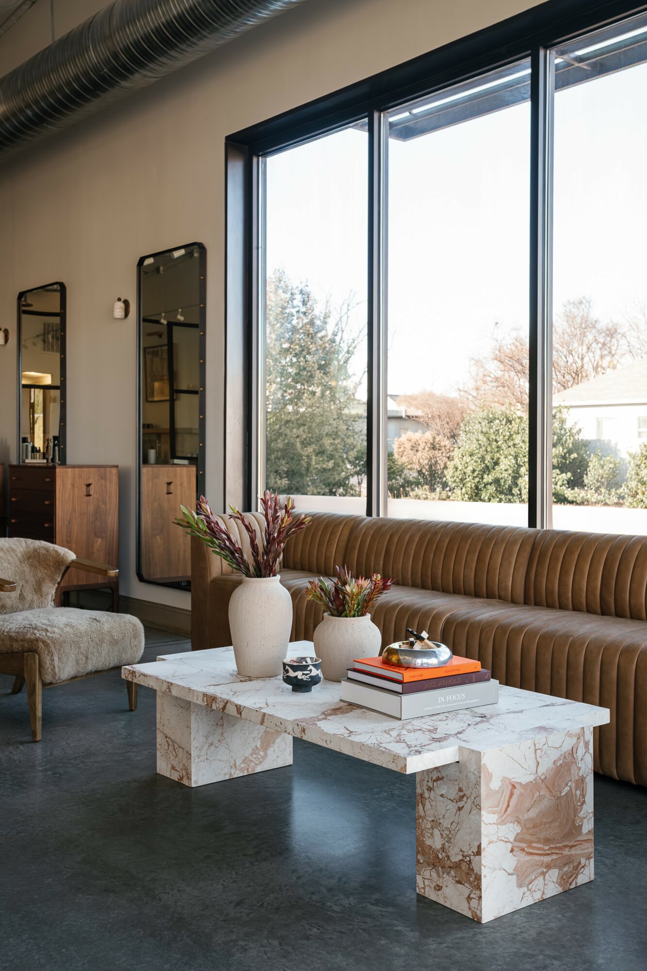 Living room with large window, sofa, marble coffee table, and decorative items.