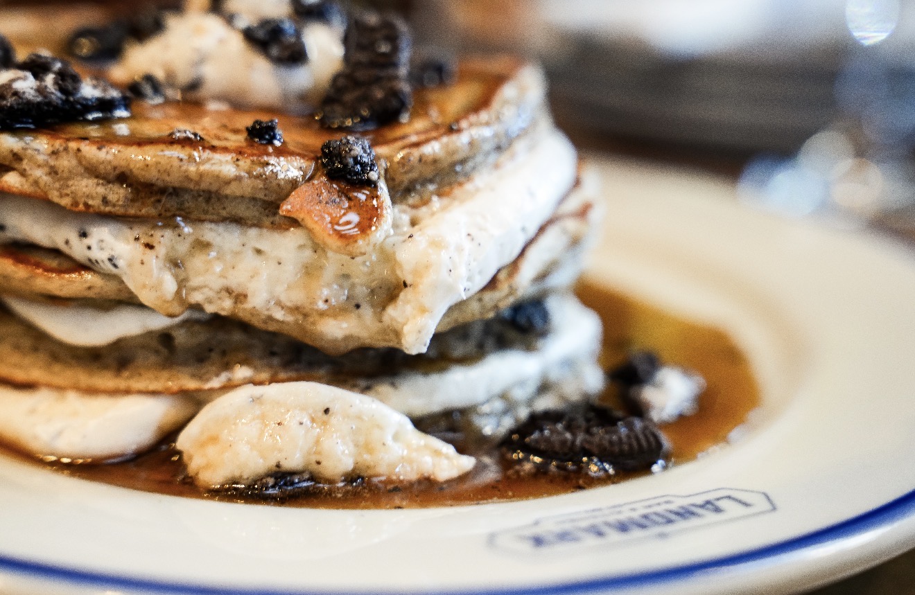 Close-up of a layered dish with grilled vegetables and sauce on a white plate.
