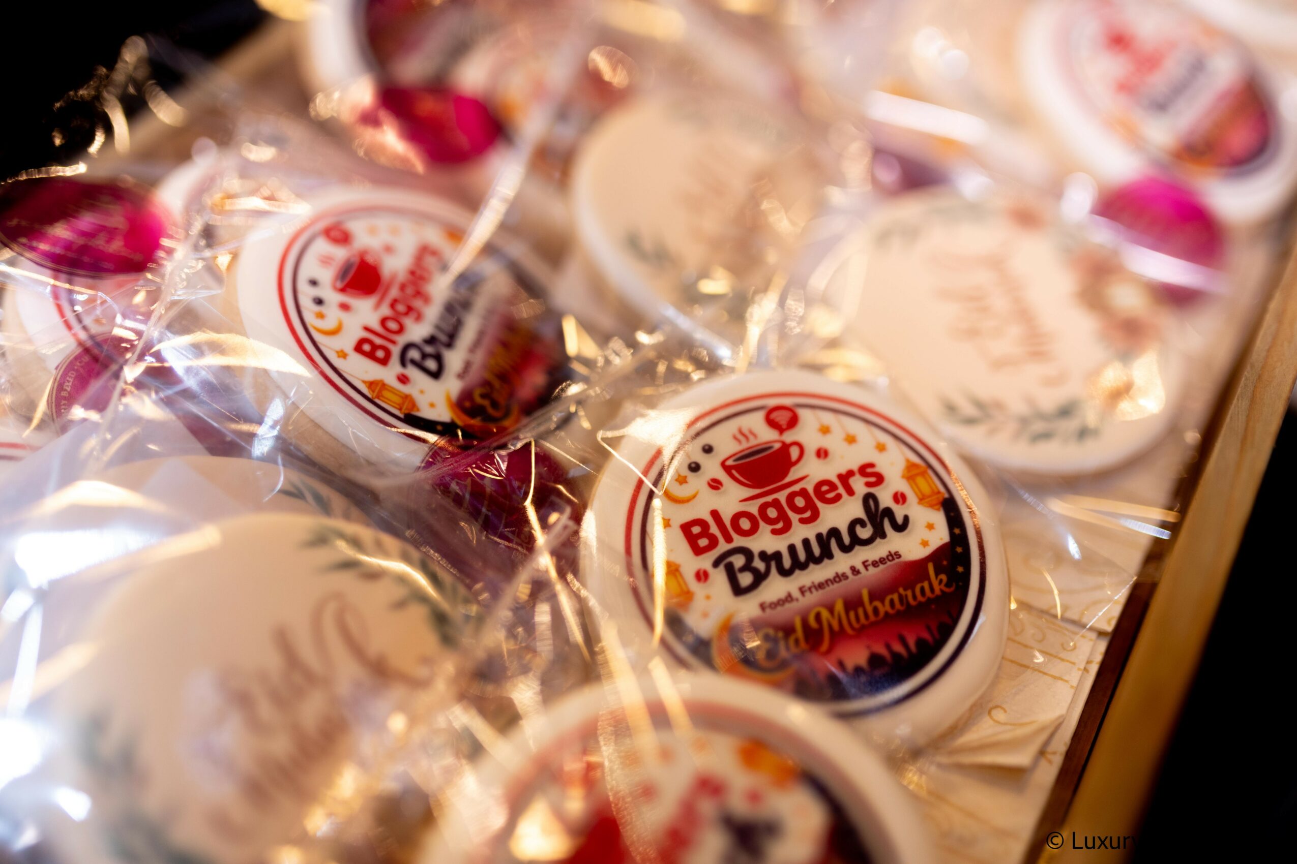 Assorted baked goods and cookies wrapped in clear plastic, with a round label reading 'Bloggers Brunch'.