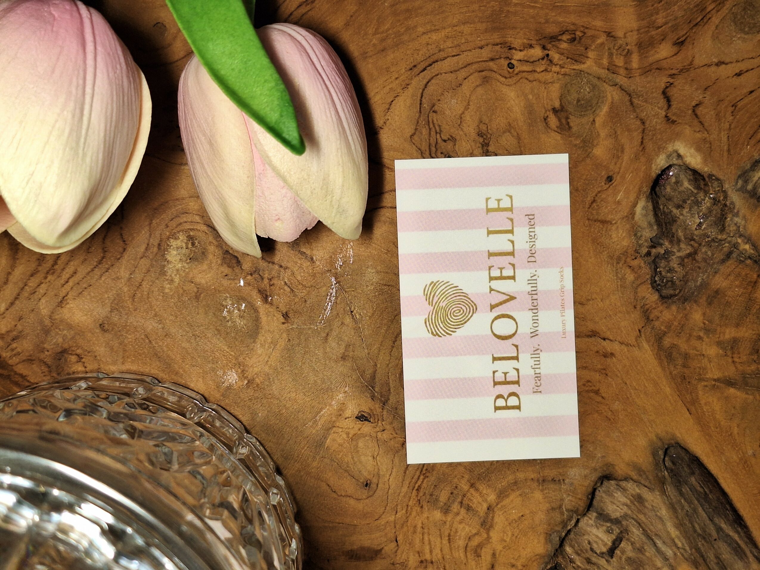 Garlic bulbs, a card with gold heart and stripes, on a wooden surface.