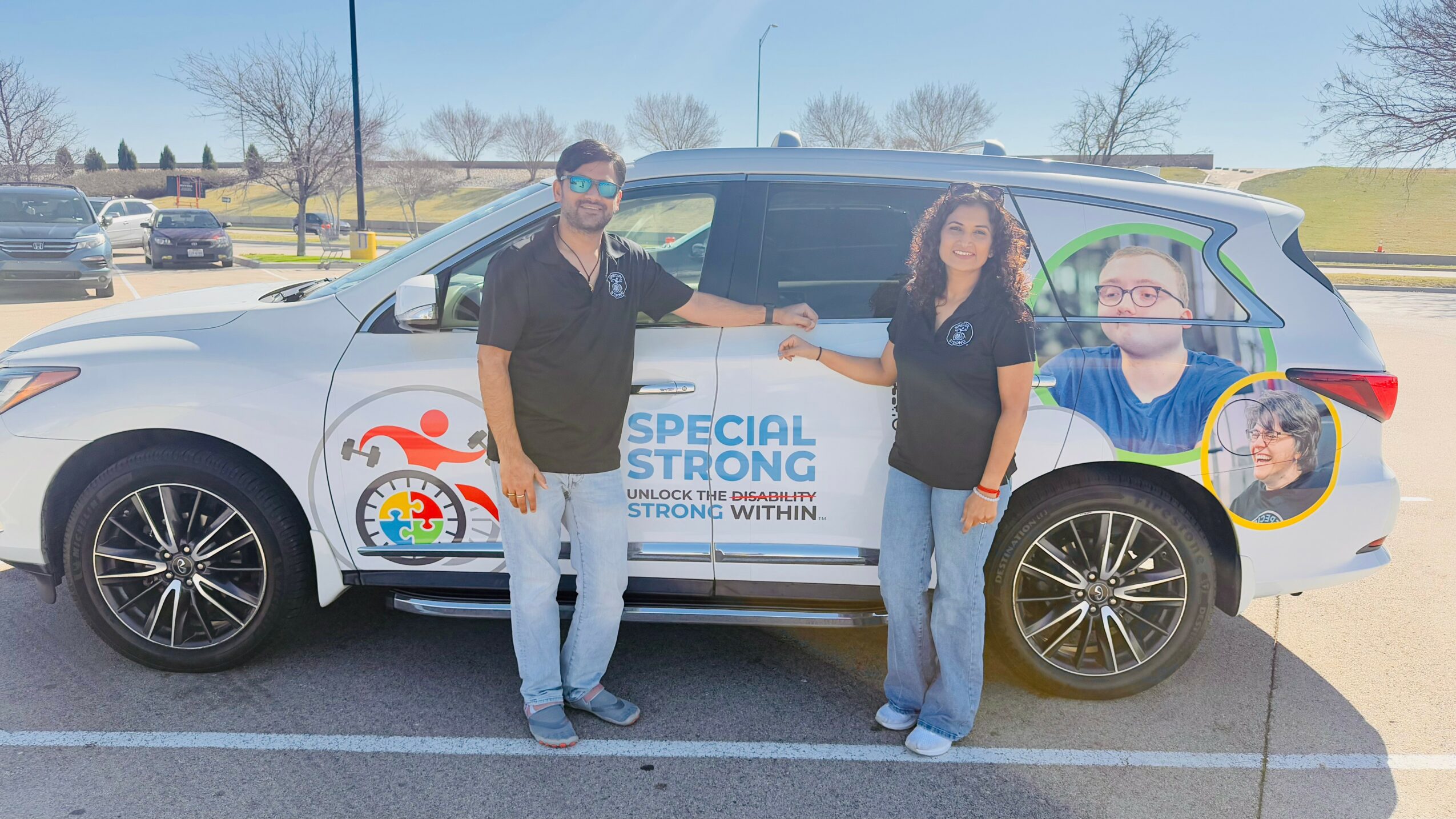Two people standing beside a decorated vehicle with a large graphic of a child and a banner reading 'Special Strong'.
