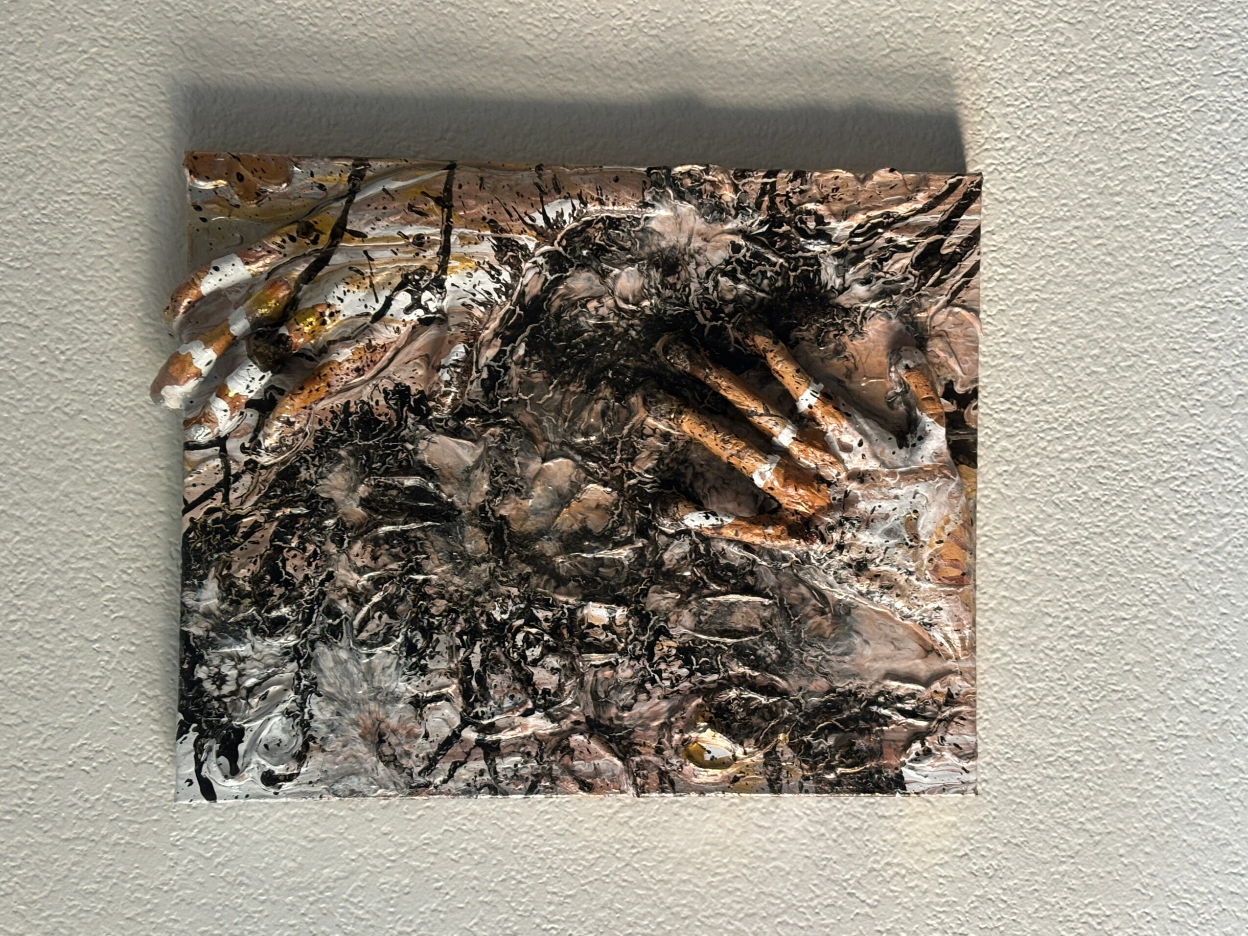 Abstract textured artwork with dark and light colors, featuring a mix of rough and smooth surfaces.