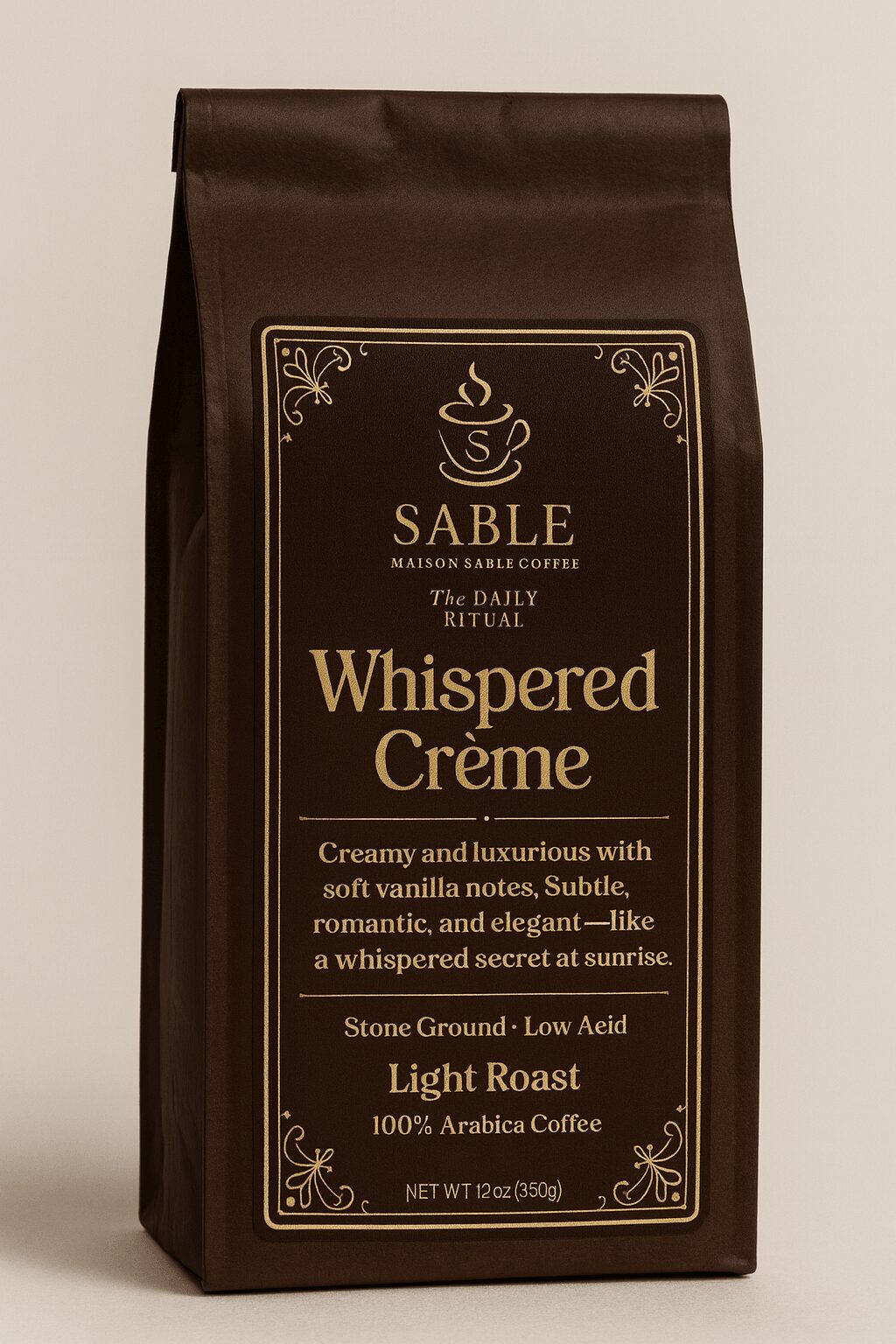 Brown coffee bag with gold and white text and decorative border, labeled Whispered Crème, Light Roast, Arabica coffee.