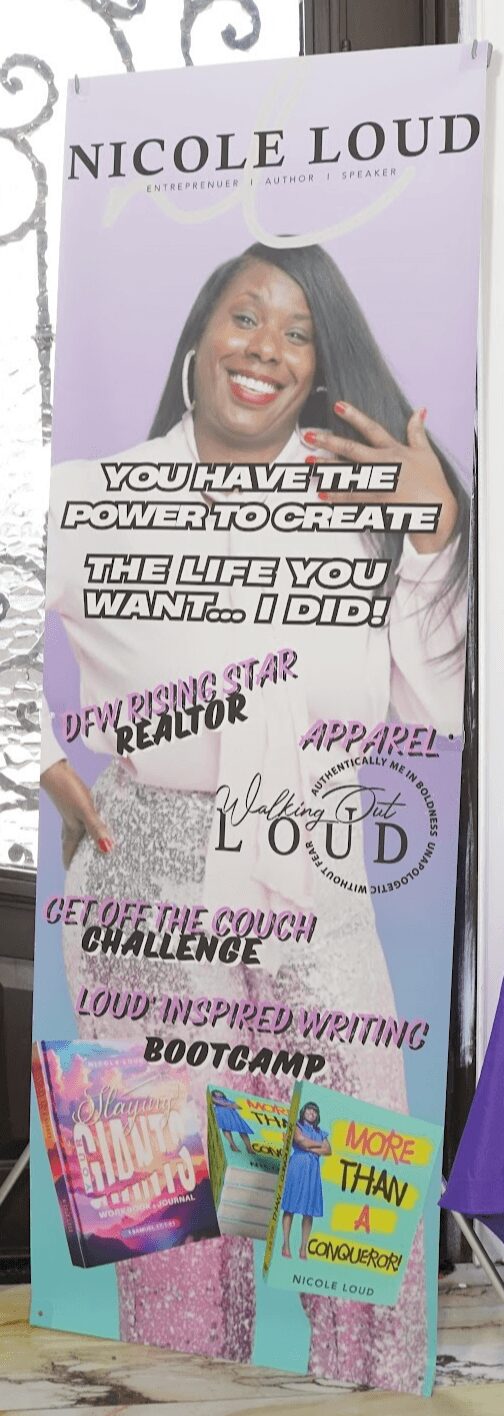 Vertical banner with a woman’s photo and text, placed near a door and a purple tablecloth-covered table.