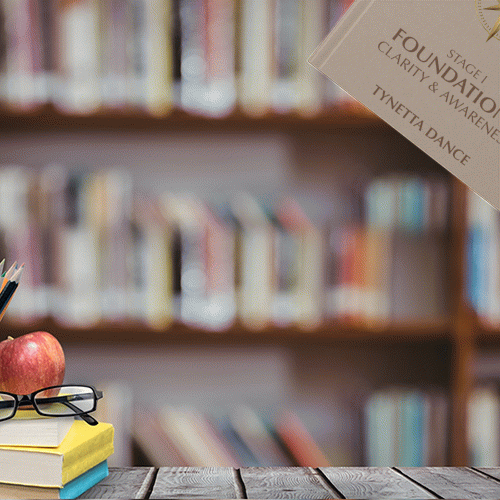 Bookshelf with blurred books in background, wooden table with an apple, glasses, and books in foreground.
