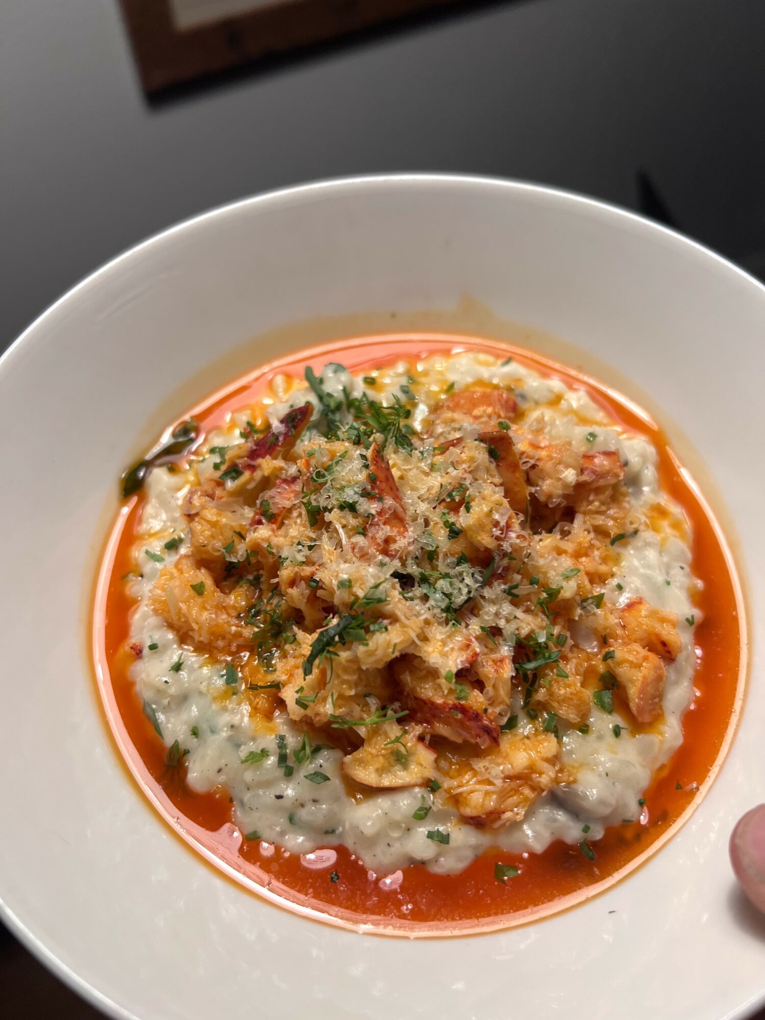 Bowl of rice topped with fried chicken, herbs, and sauce, garnished with green herbs.