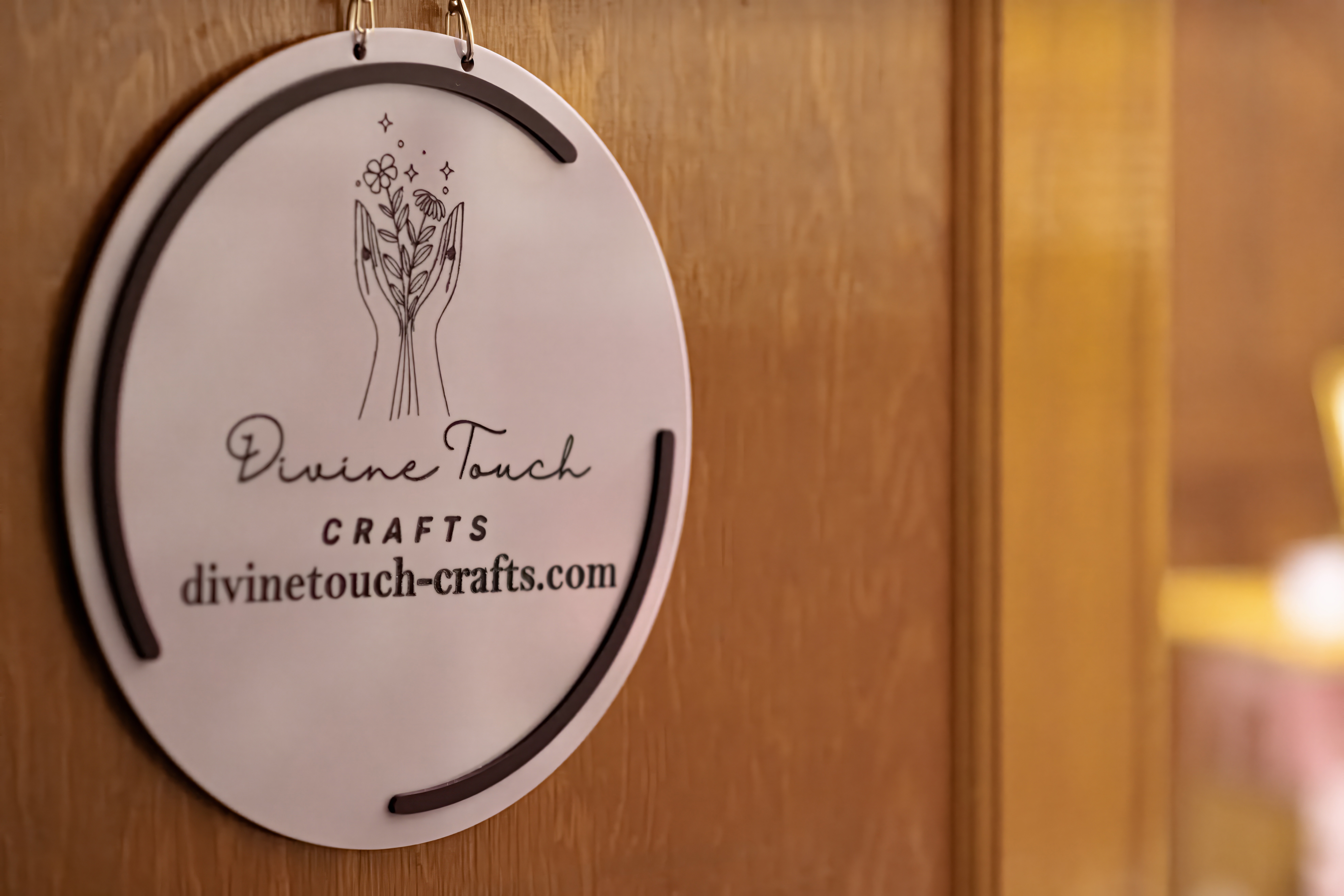 Round sign with plant illustration and text, hanging on a wooden surface.