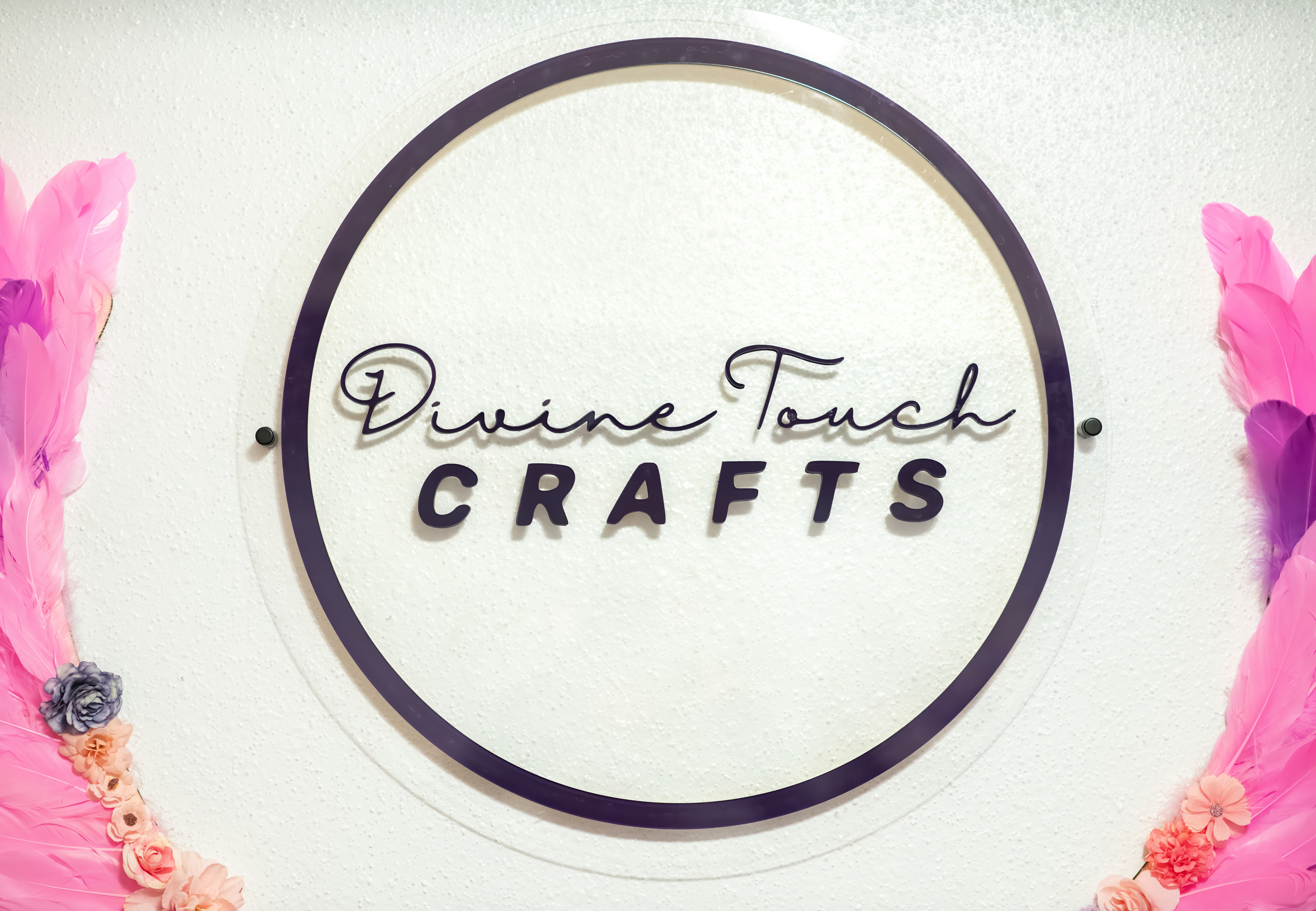 Sign with text 'Divine Touch CRAFTS' inside a circle, surrounded by pink and purple flowers.