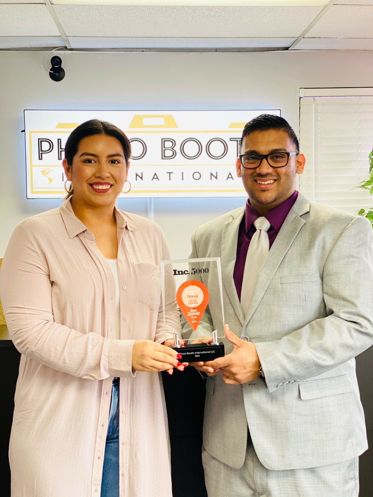 Two people, a woman and a man, holding an award together in front of a sign that reads 'PHILIPPINE BOOT CAMP.'