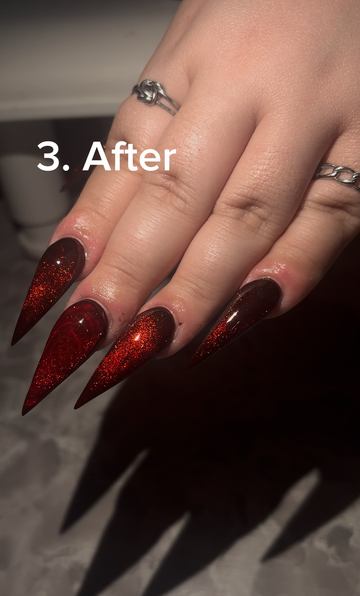 Hand with long, red glittery nails and rings, with text '3. After' overlayed.