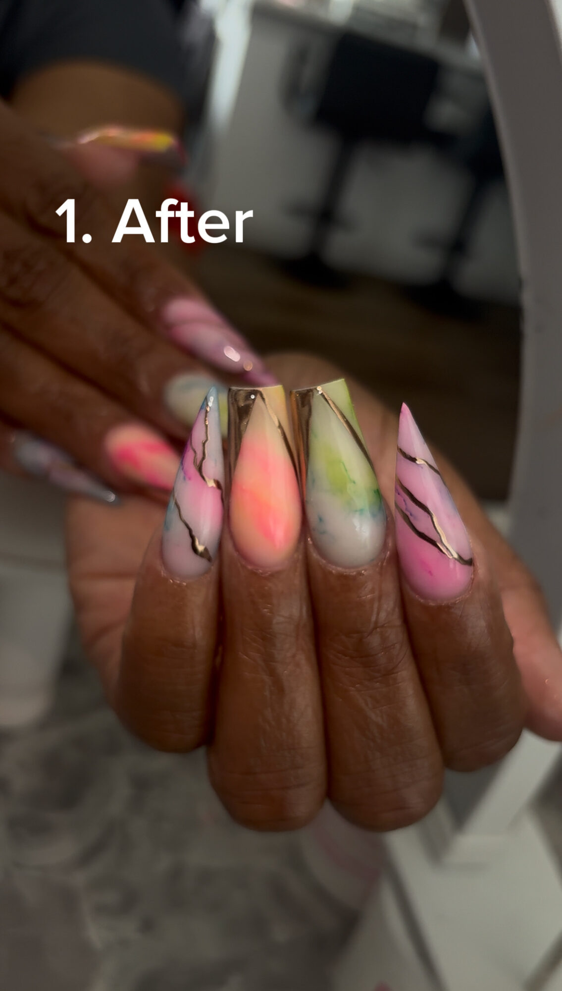 Close-up of a hand with colorful, decorated nails, holding a small object, with text '1. After' visible.