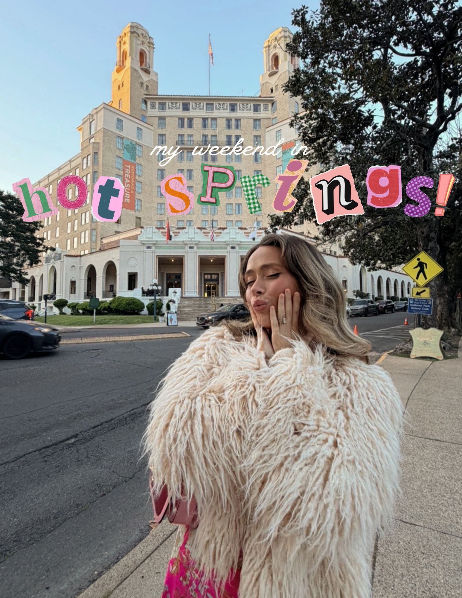 Young woman with long hair in a fluffy coat standing on sidewalk in front of a large building with colorful sign reading 