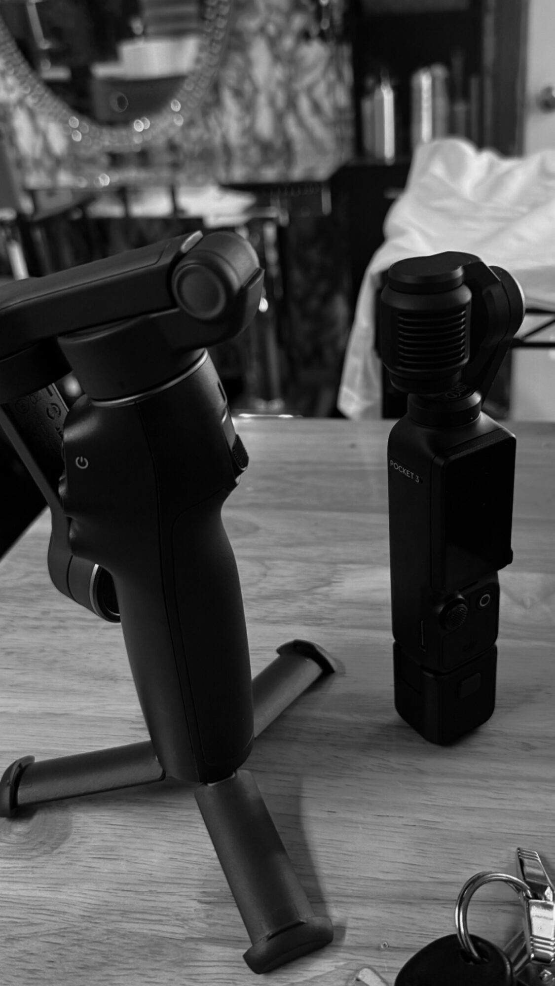 Black handheld device with a handle and a mounted attachment on a wooden surface, with a blurred background.