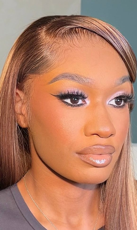 Close-up of a woman with long, straight hair, makeup, and a neutral expression.