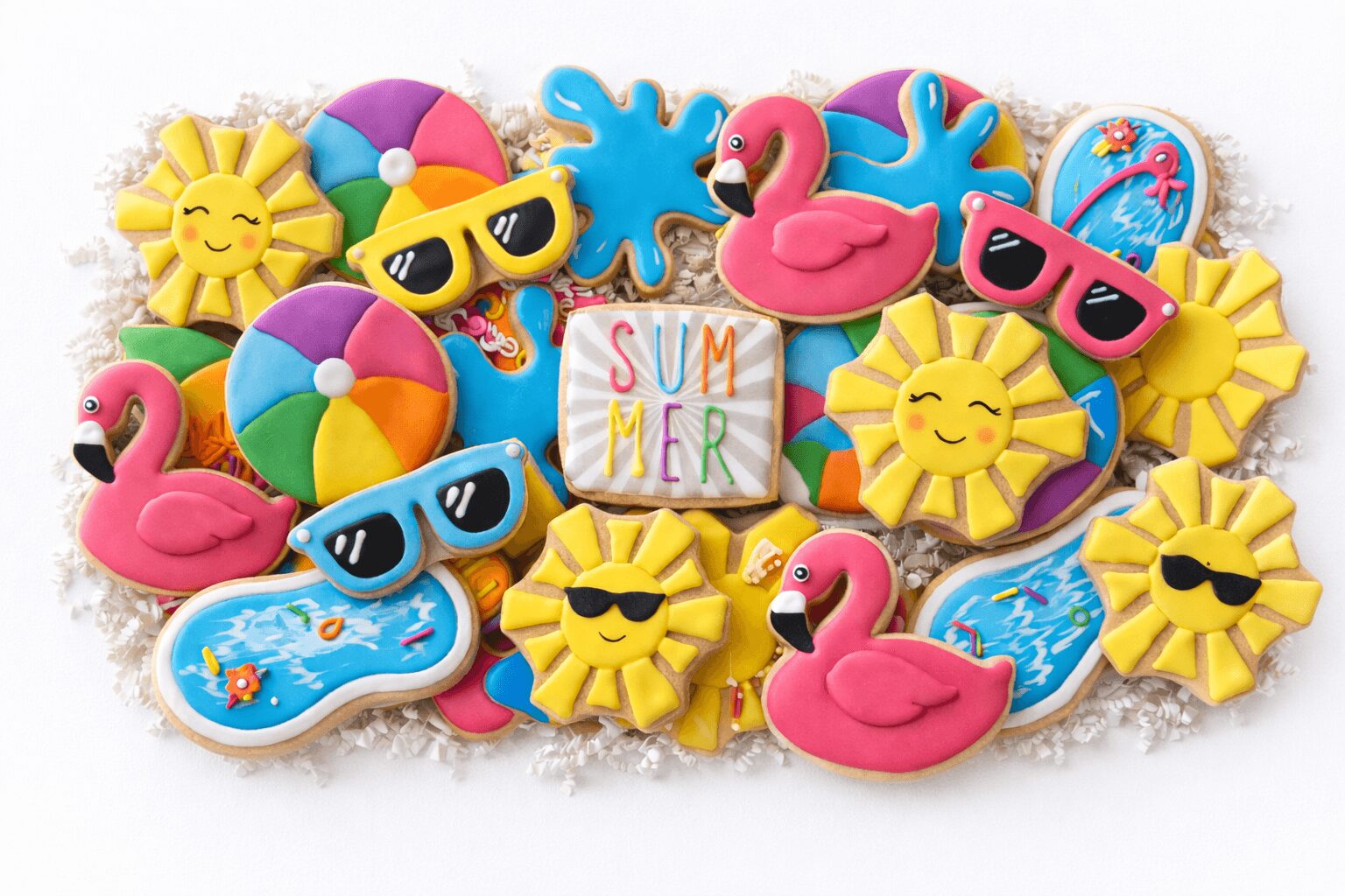 Colorful summer-themed cookies with flamingos, suns, sunglasses, beach balls, and a sign reading 'SUMMER'.