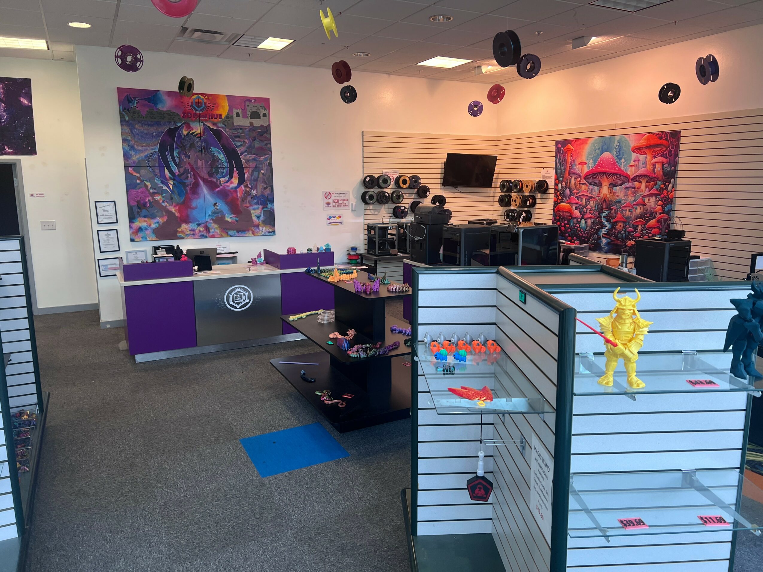 Indoor store with colorful artwork, purple counters, and display shelves with toys, music equipment, and decorations.