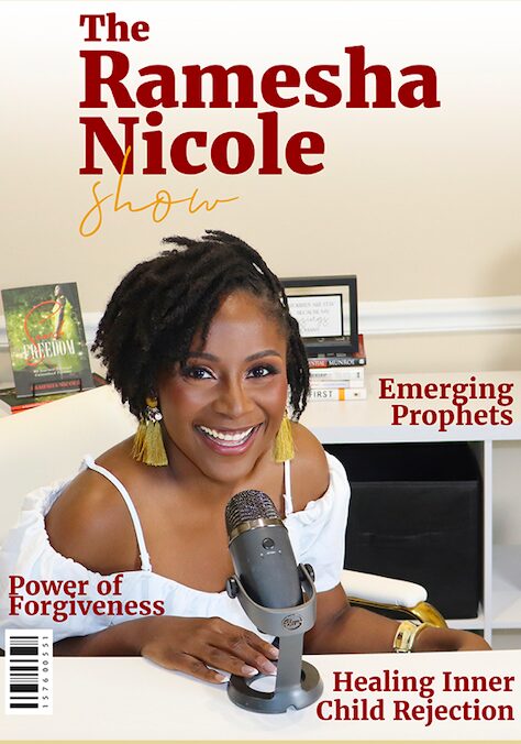 Woman with short curly hair smiling at microphone in a room with books and framed pictures