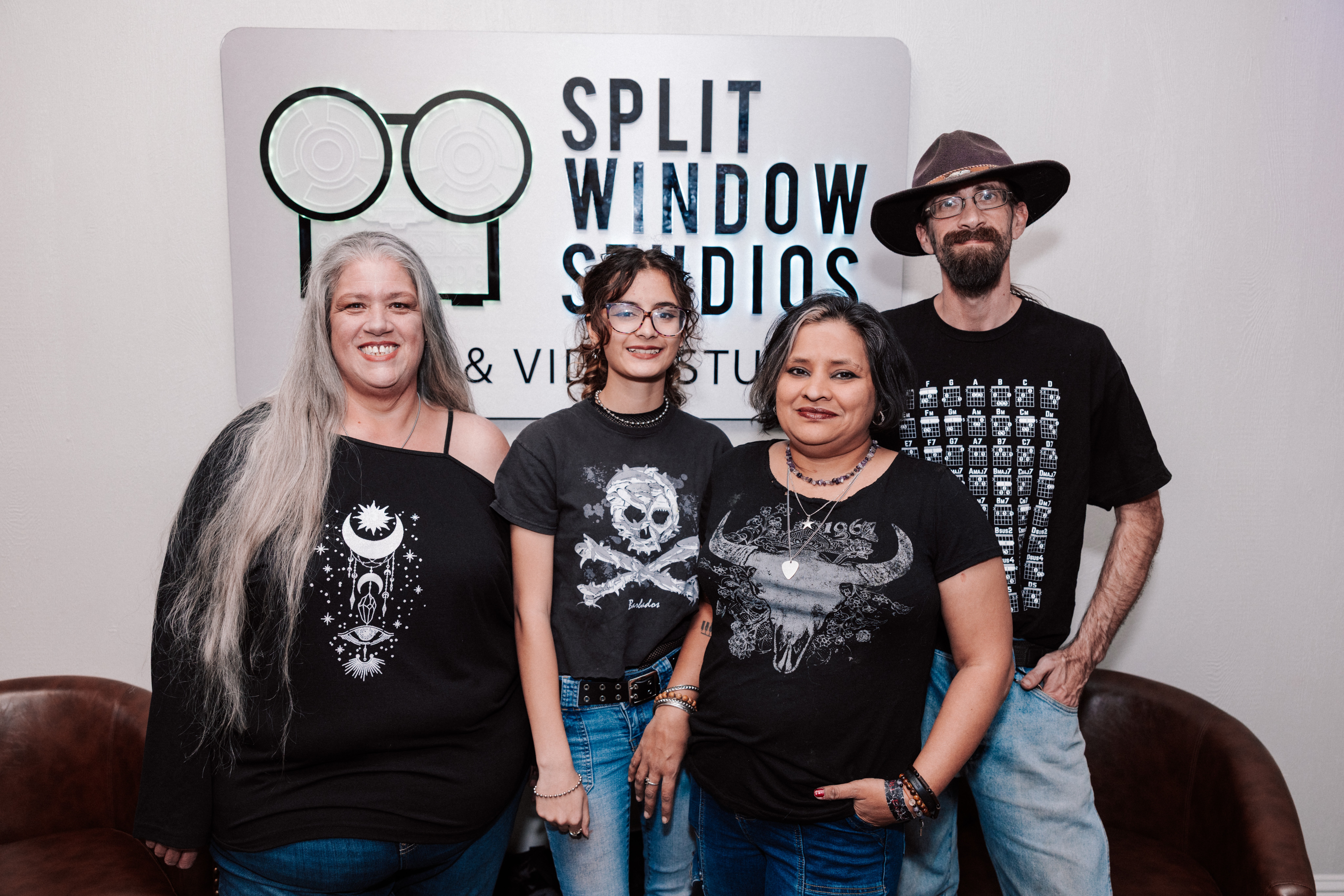 Four people standing in front of a sign that reads 'Split Window Studios & Video Studio,' smiling at the camera.