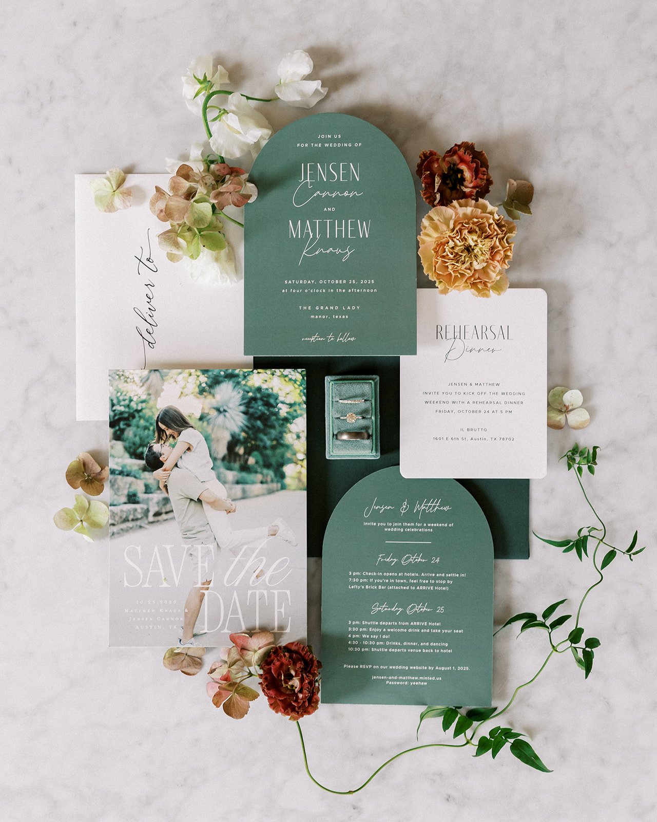 Wedding invitation suite with floral decorations, a photo of a child, and a small box, arranged on a light surface.