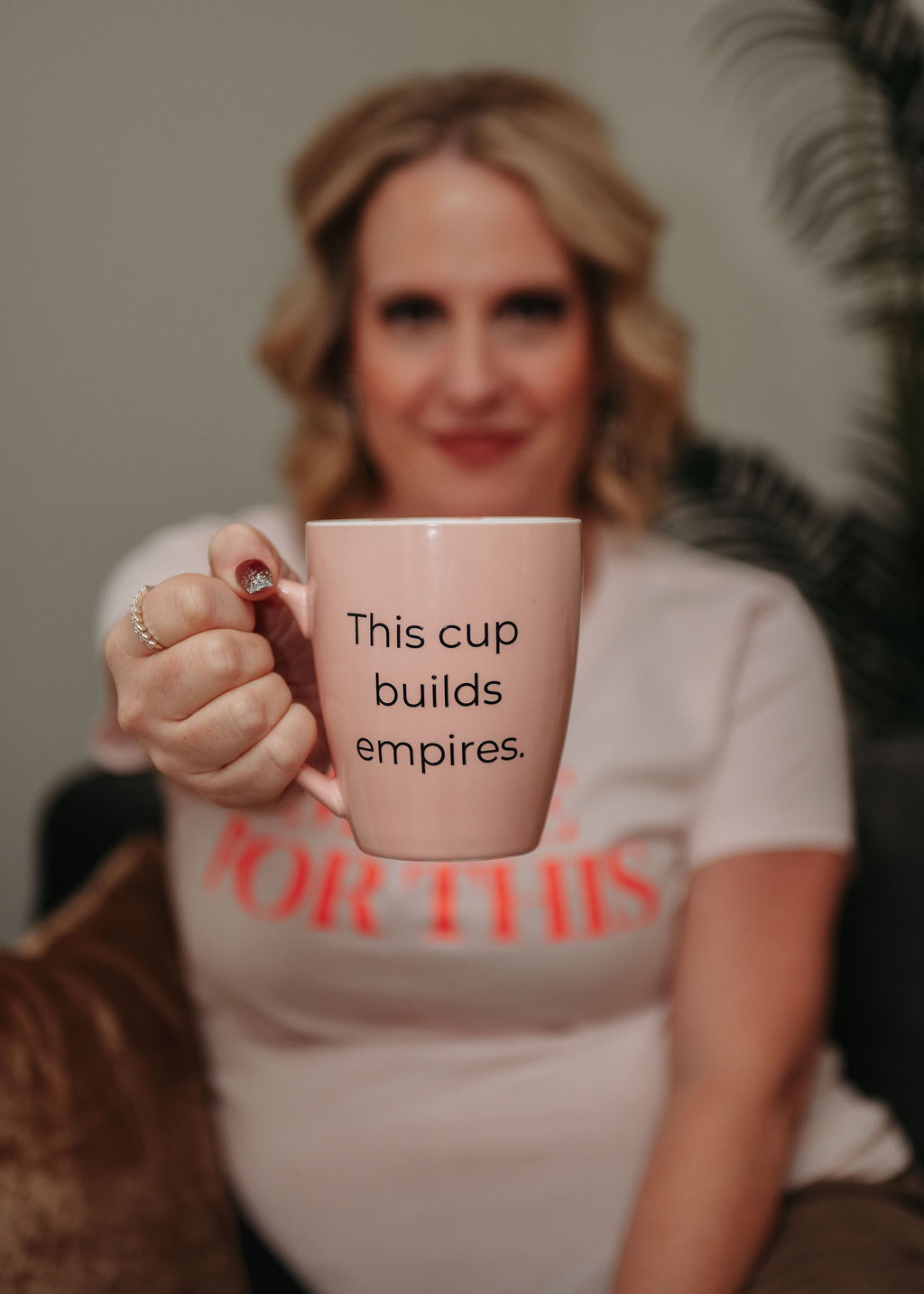 Woman holding a pink mug with the text 