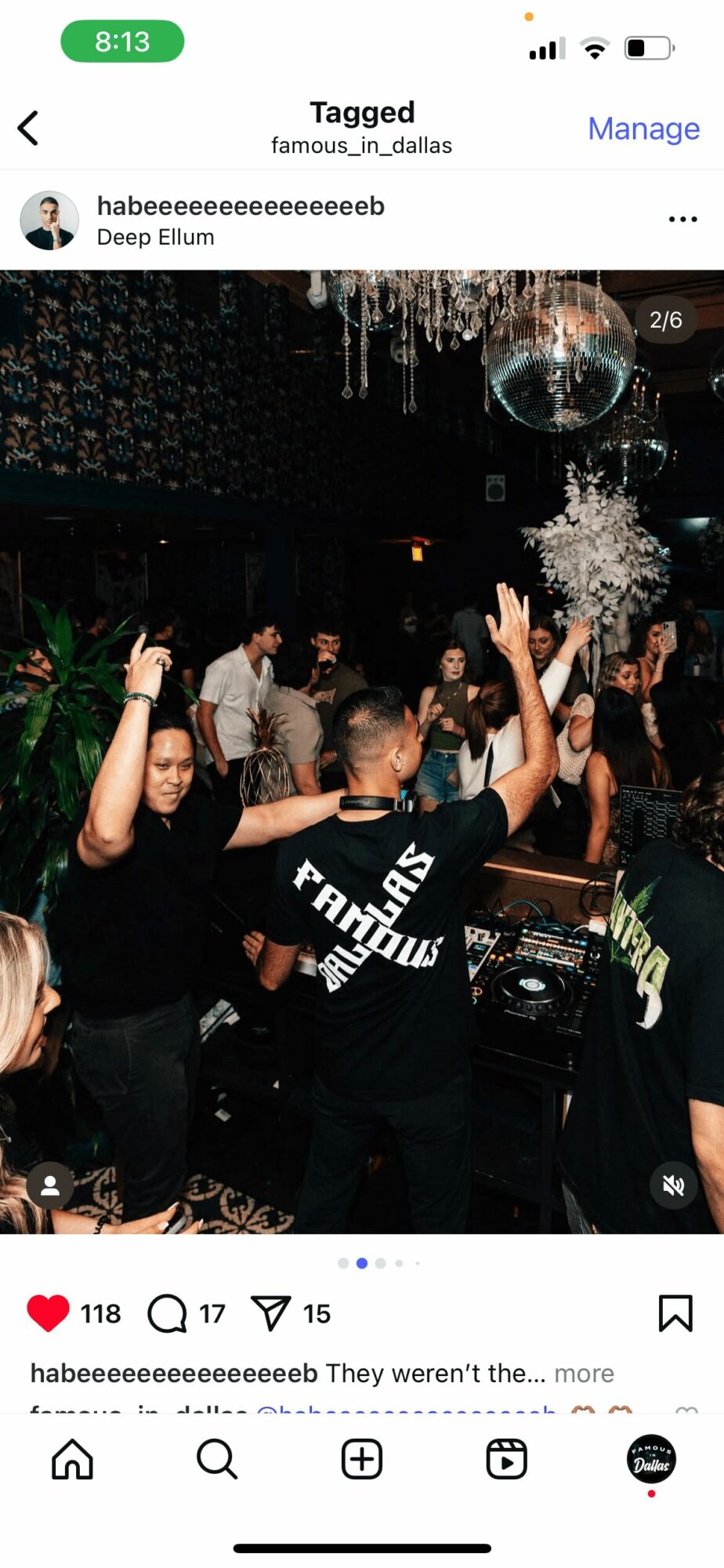 People dancing at a party with decorations and a DJ booth, some with hands raised, in a dark setting.