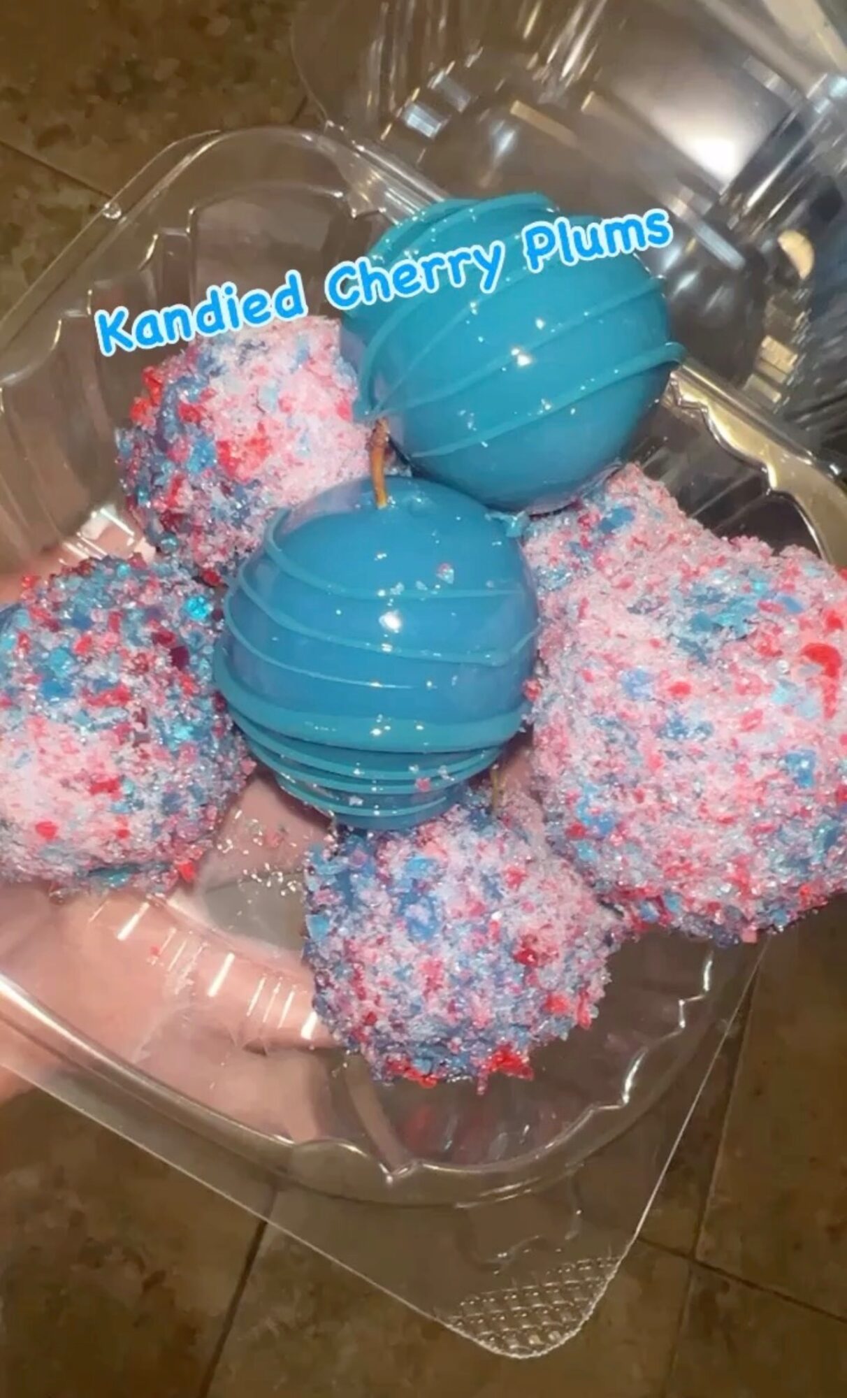 Clear container with blue balls and cherry plum candies covered in pink and blue sprinkles, with text overlay.