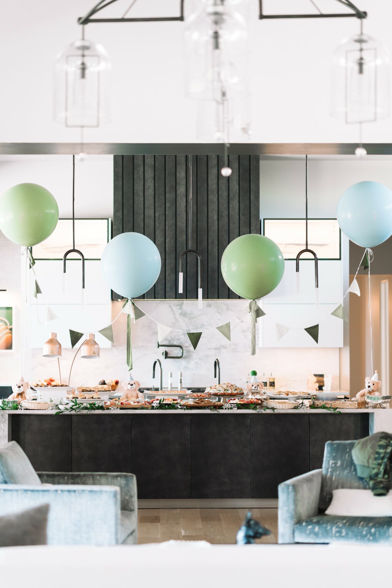 Decorative interior with hanging balloons, a marble countertop, and seating area, featuring modern design elements and lighting fixtures.
