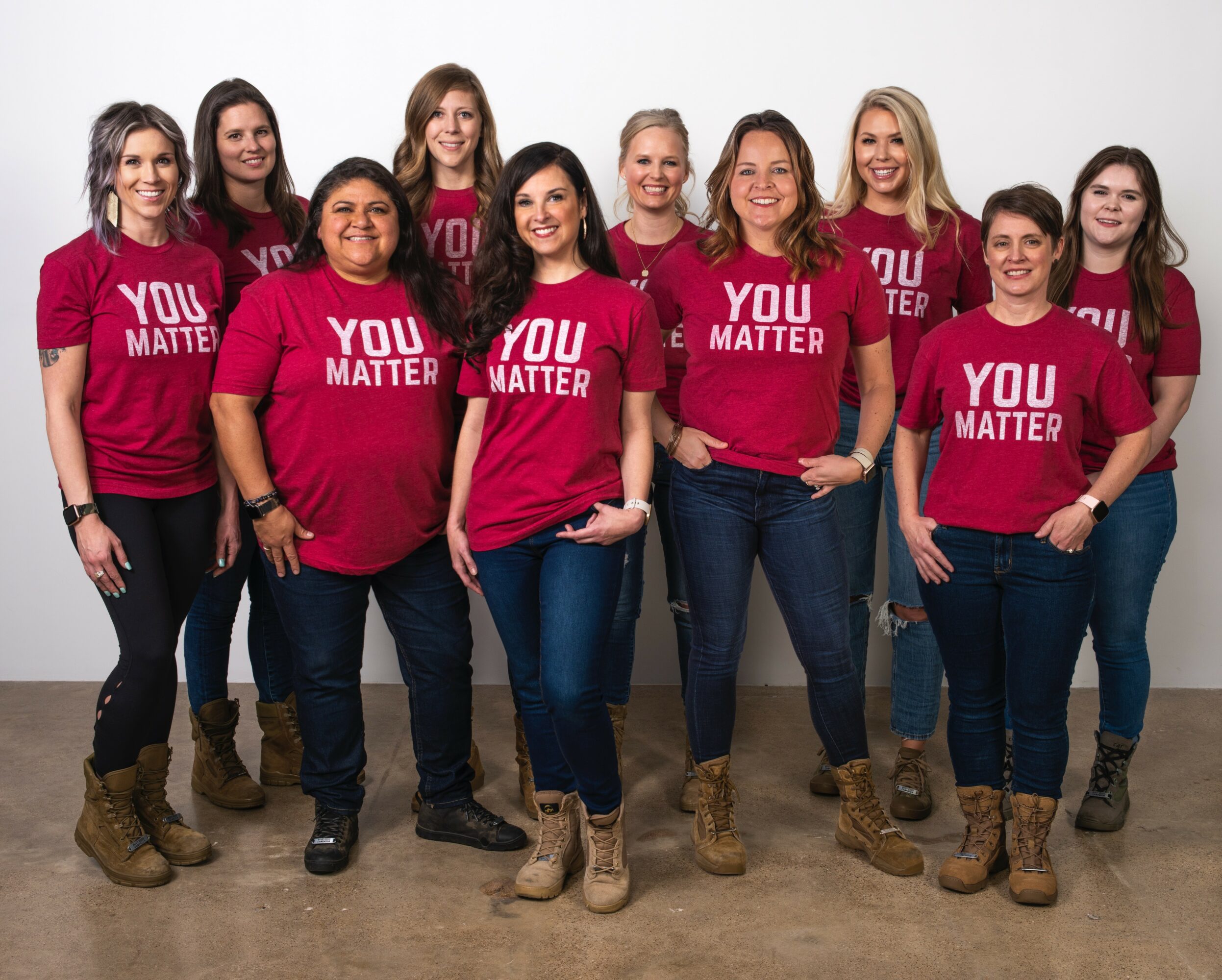 Group of ten women wearing matching pink shirts with 'You Matter' text, standing against a white background.