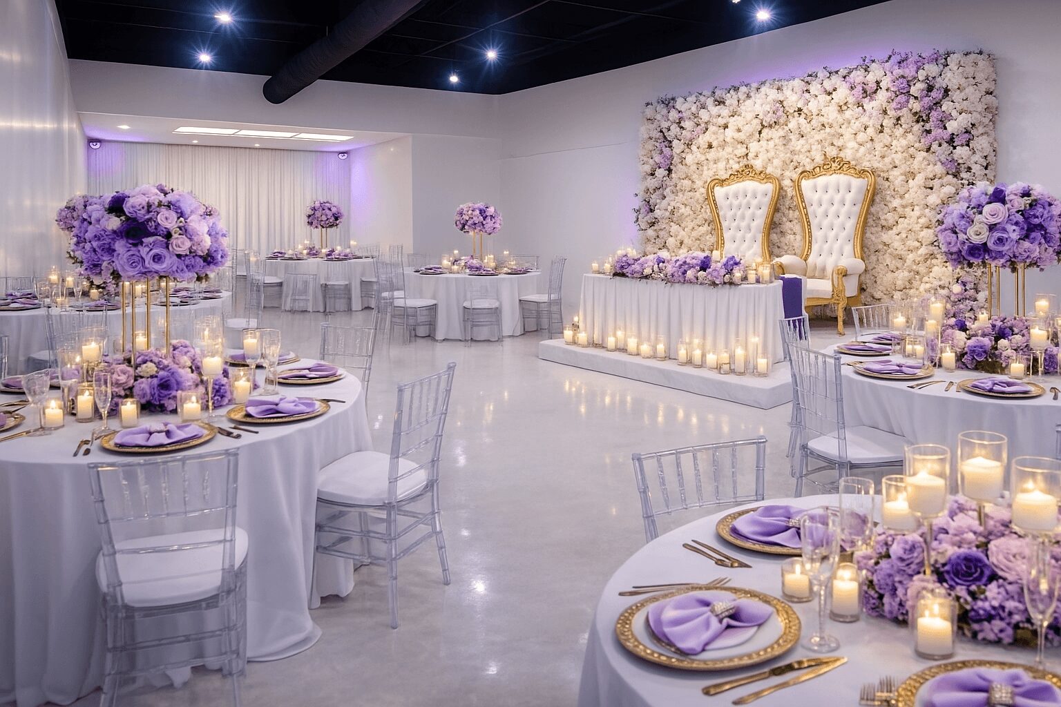 Elegant event space decorated with purple and white flowers, candles, and seating for a celebration, with a floral backdrop and chairs.
