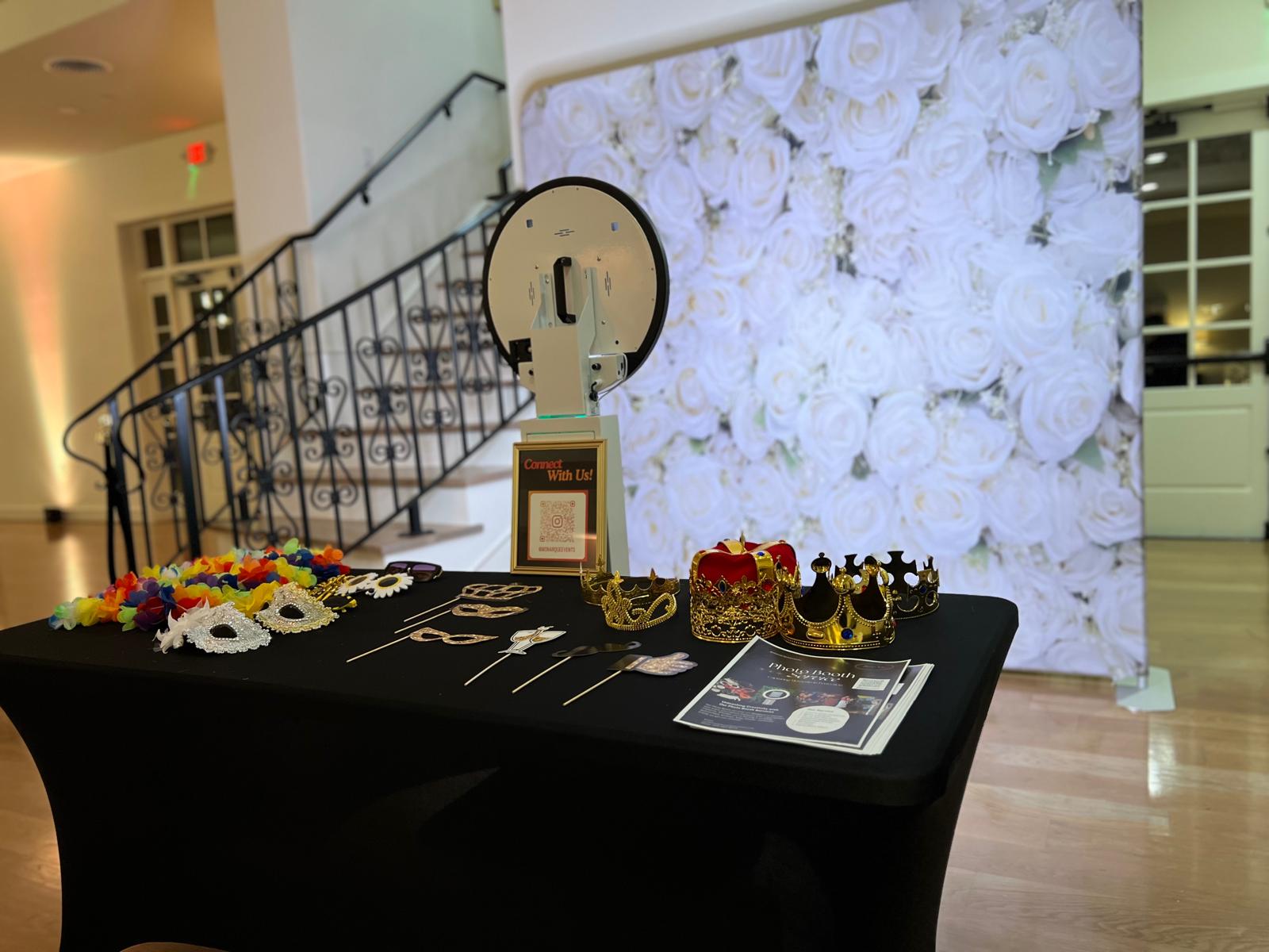 Table with jewelry and accessories in front of a floral backdrop, staircase on the left, and a white wall on the right.