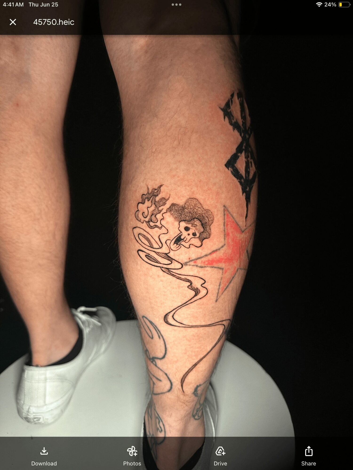 Tattoo of a girl with curly hair, smoking, with a star and abstract lines on a person's calf.