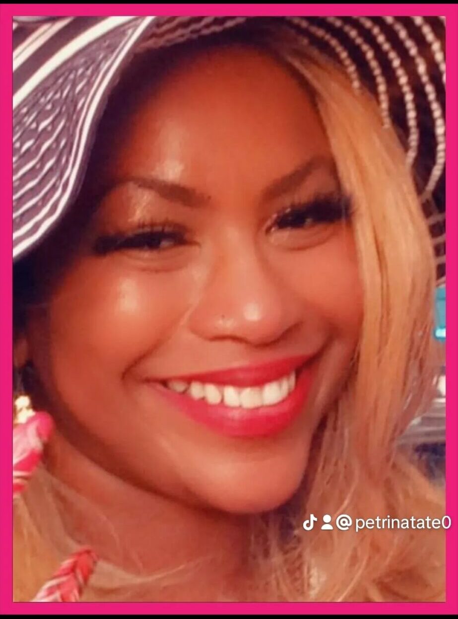 Smiling woman wearing a wide-brimmed hat with pink and white stripes, close-up portrait, pink border.