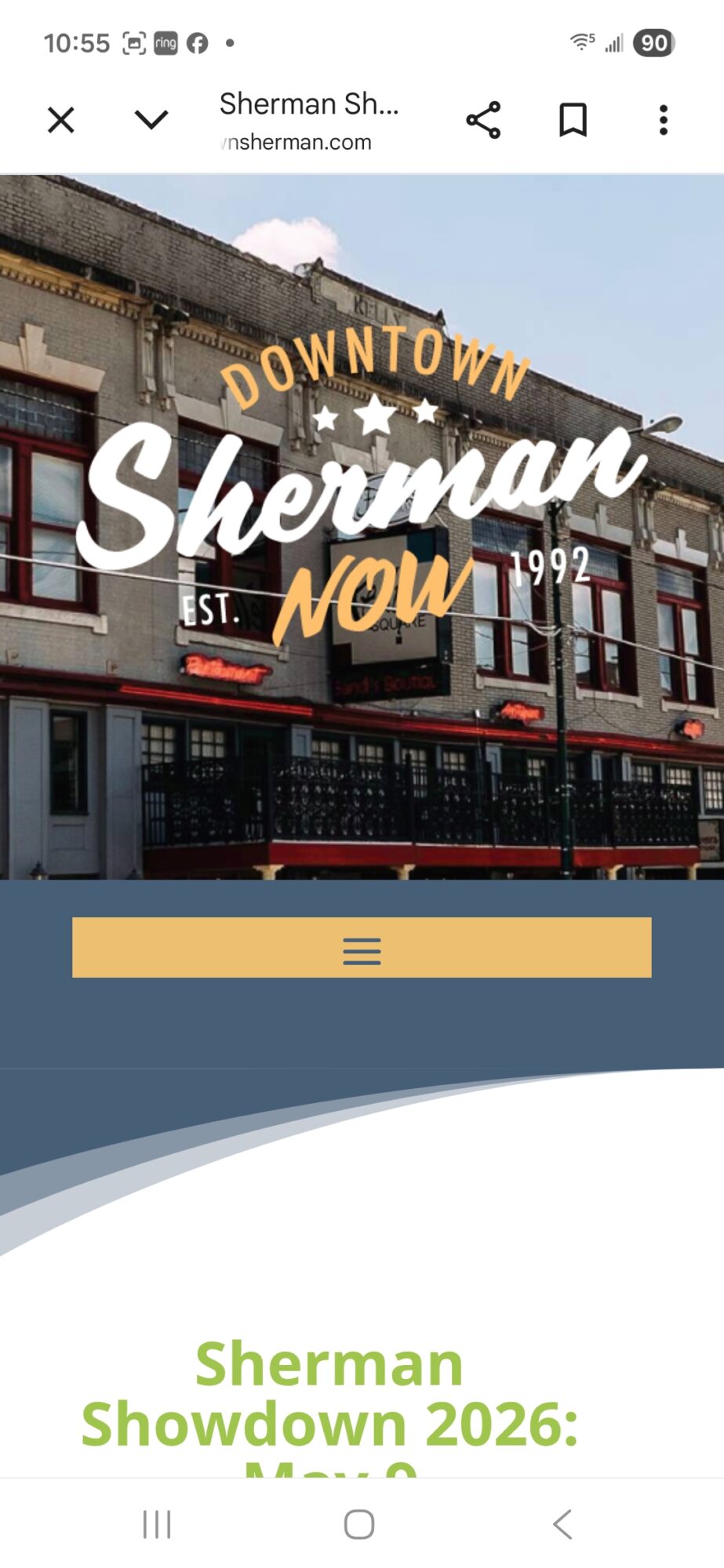 Building with signage reading 'Downtown Sherman Now,' two-story brick structure with windows and a balcony, clear sky background.