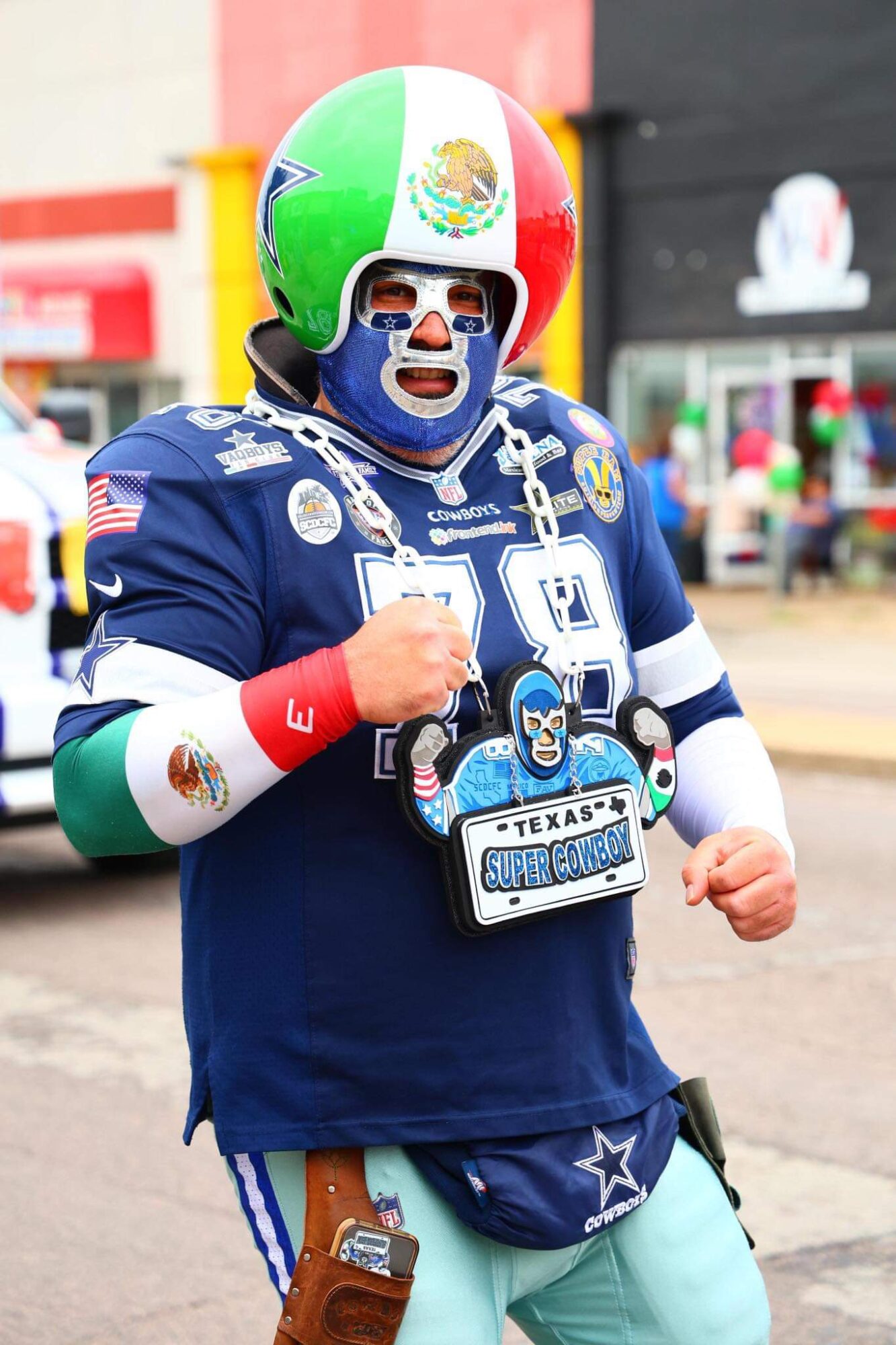 Person dressed as a football player with a colorful helmet, face paint, and a blue jersey, standing outdoors.