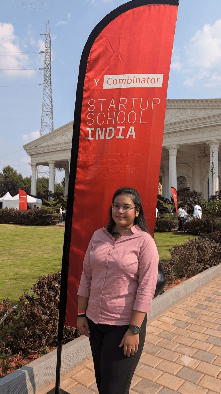Woman standing outdoors near a red vertical banner with text, in front of a white building with columns.