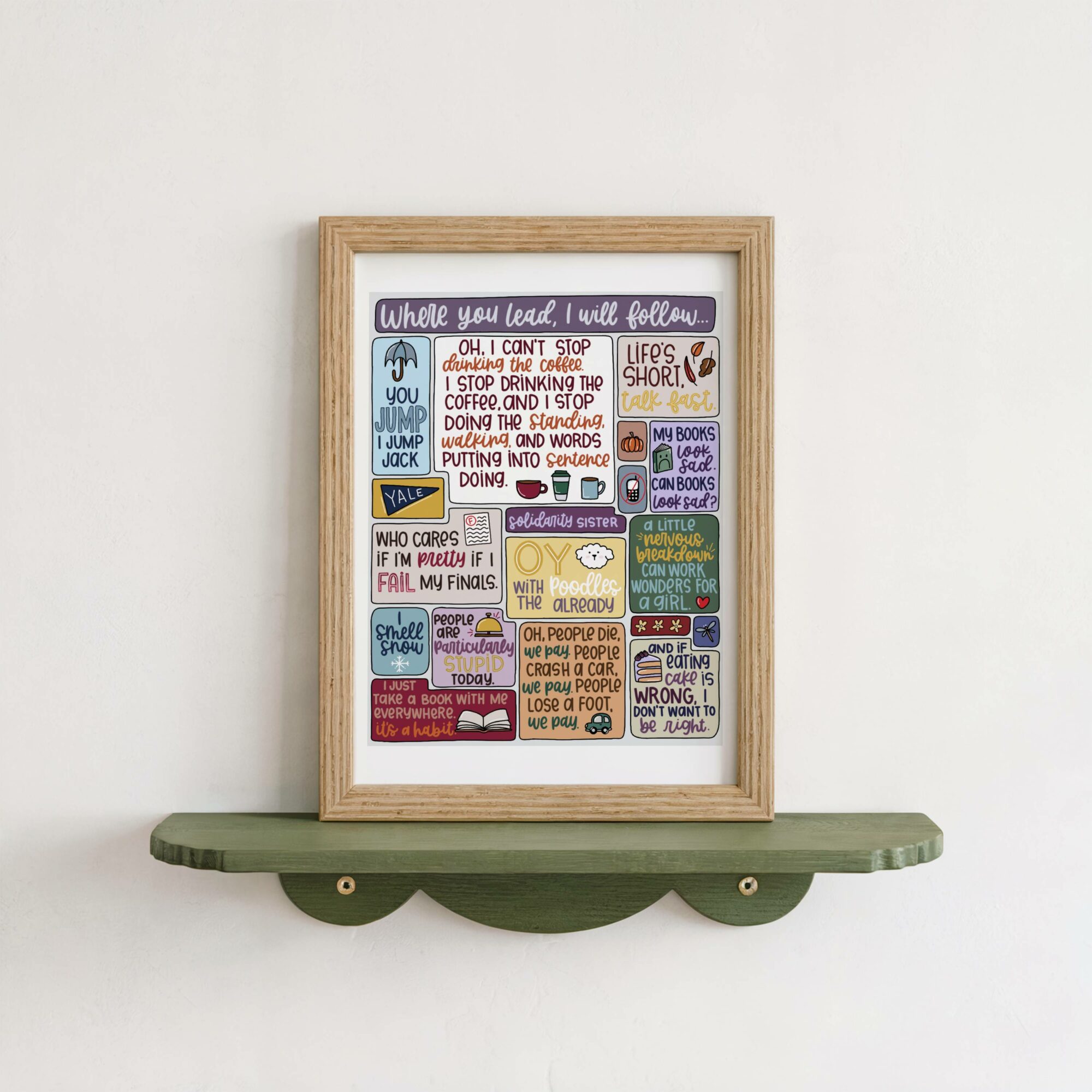 Framed colorful collage of motivational quotes and illustrations on a white wall, resting on a green shelf.