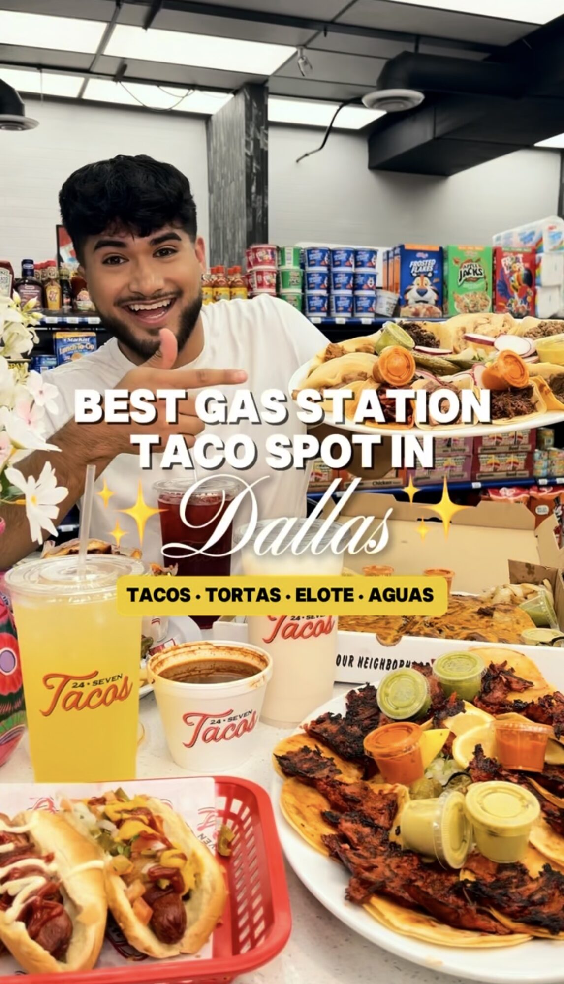Young man smiling at a taco stand with various tacos and drinks displayed, inside a store with shelves of snacks.