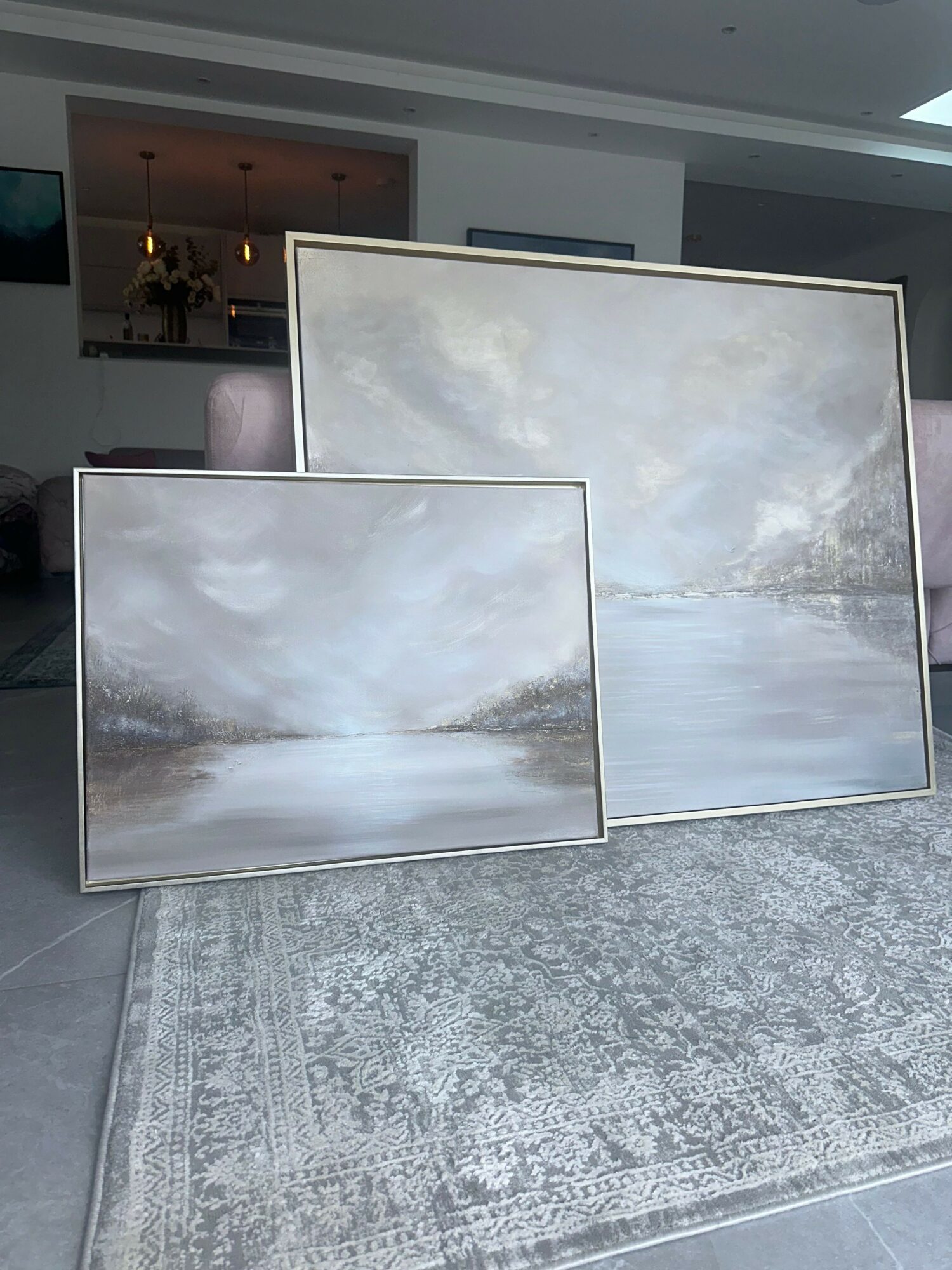 Two mirrored tables reflect a cloudy sky, placed on a light-colored rug in a modern room.