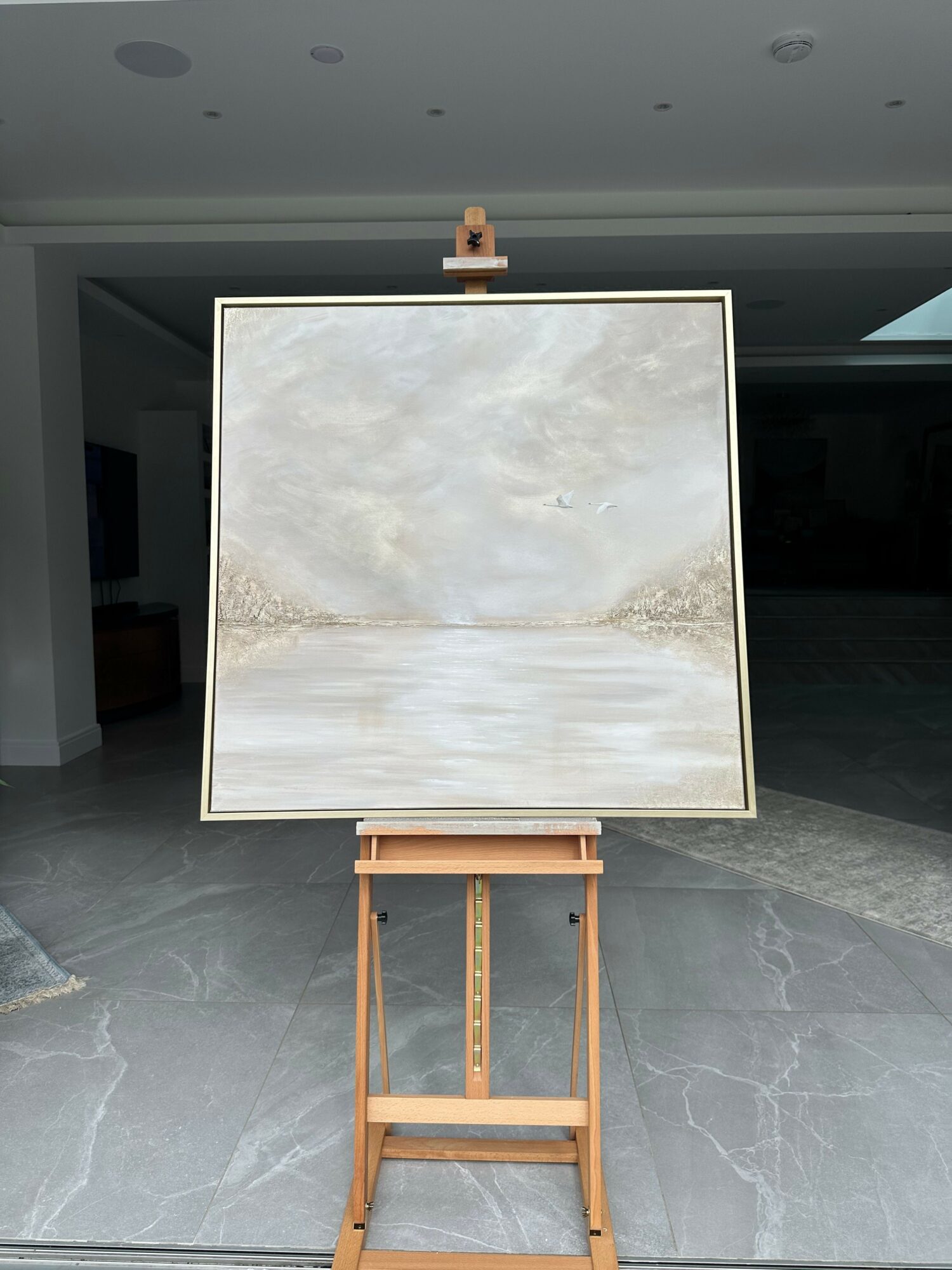 A whiteboard on a wooden stand in a room with gray walls and floor.