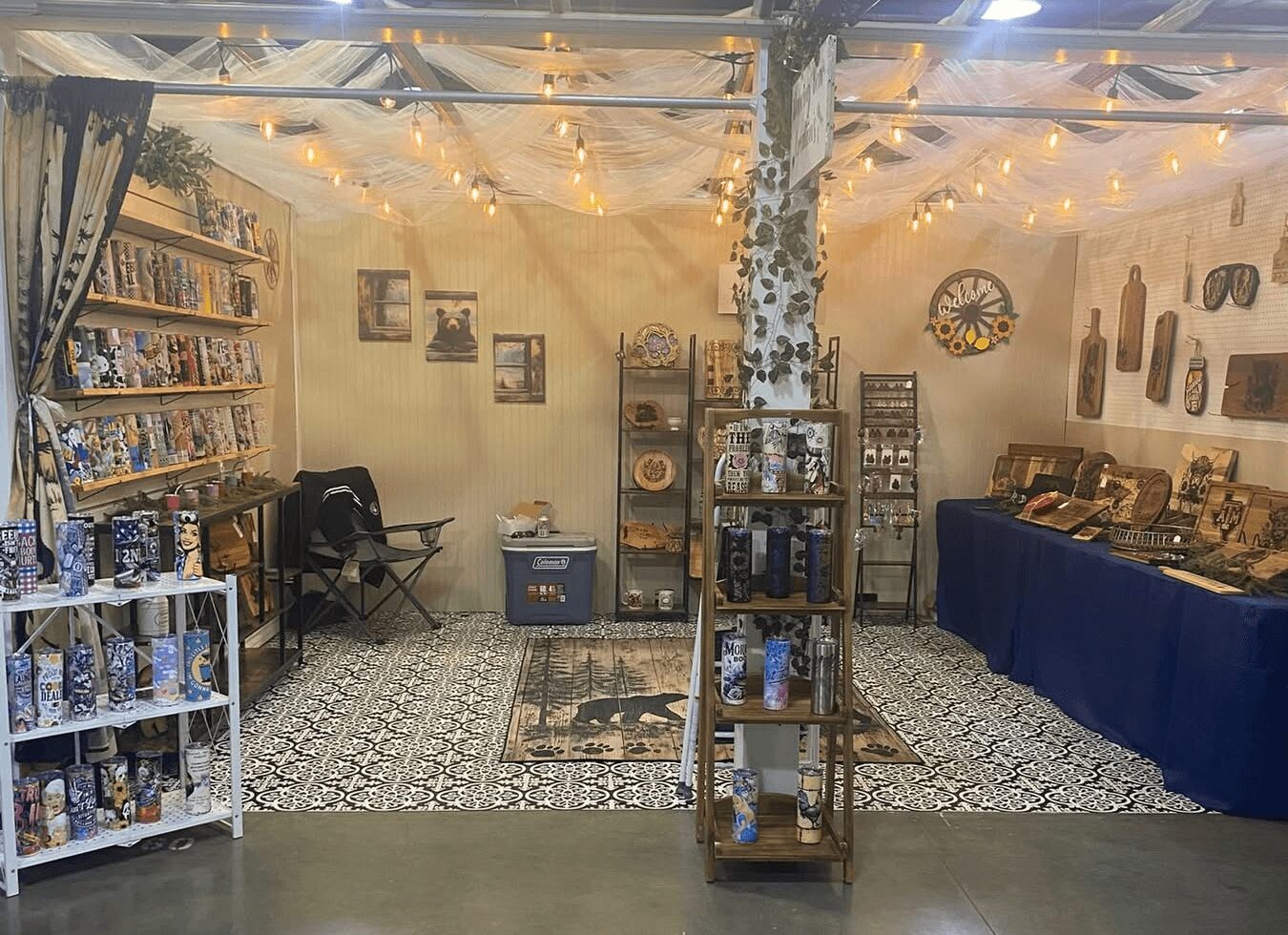 Interior of a cozy room with shelves, a table, and a seating area, decorated with string lights and wall art.