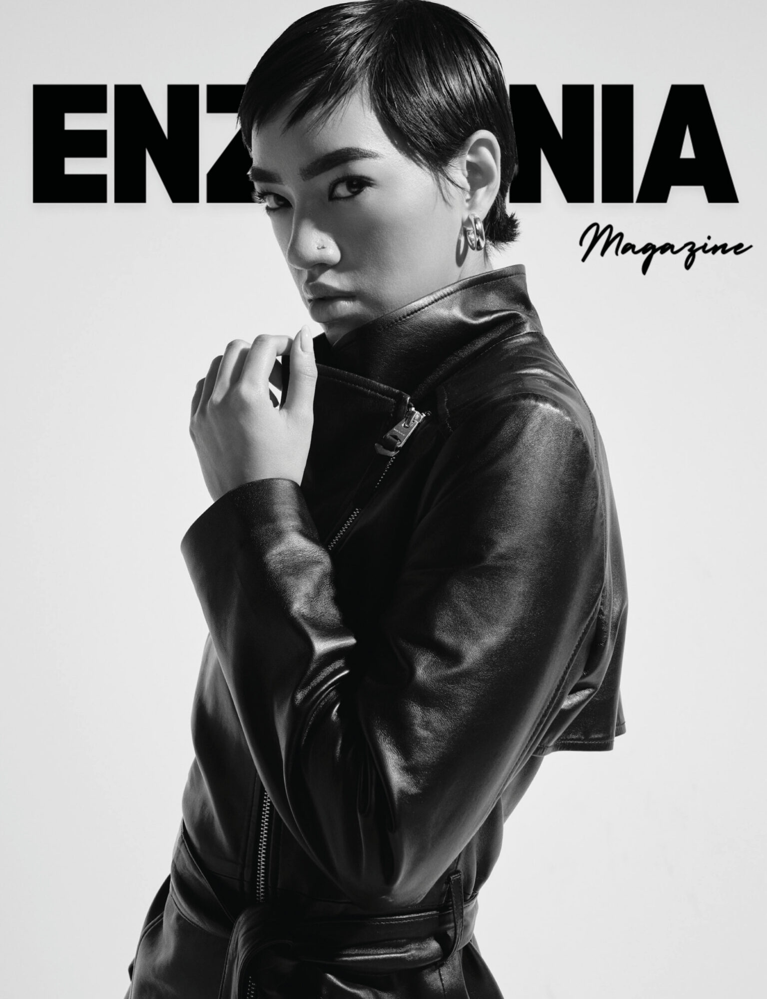 Black and white photo of a woman with short hair wearing a leather jacket, looking at the camera with a serious expression.