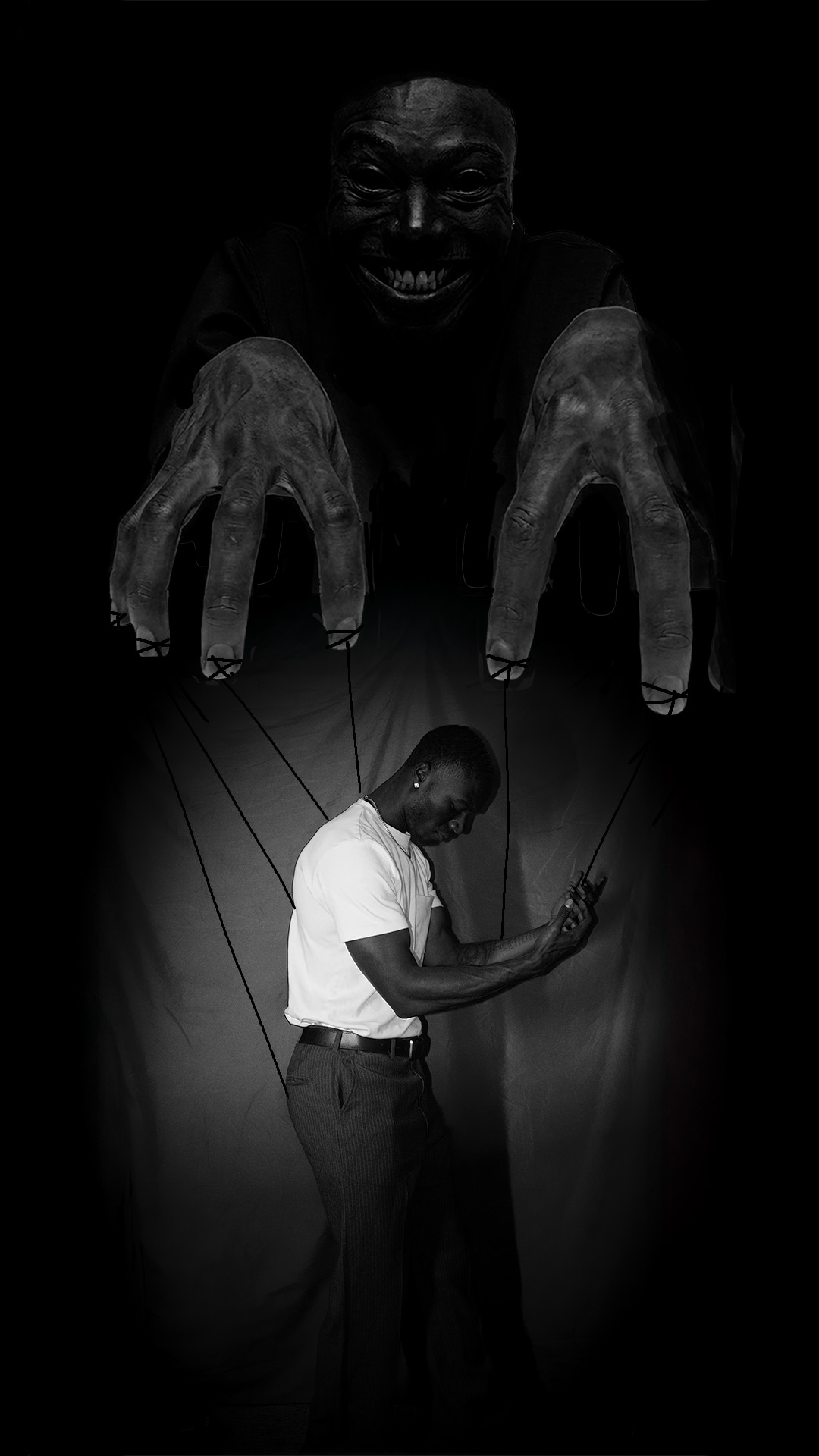 Person holding strings attached to puppet-like figure, with a dark, sinister face looming above. The scene is in black and white.
