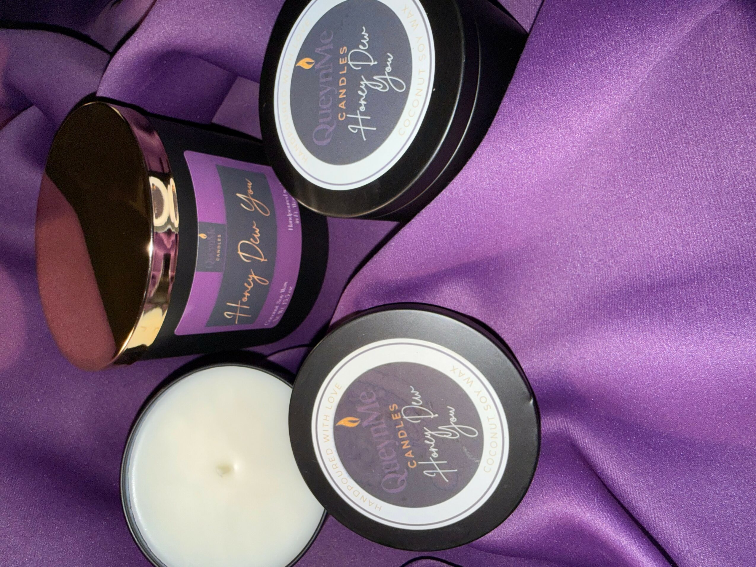 Three containers of scented candles on purple fabric, with labels reading 'Lush & Cozy' and 'Relax & Unwind'.