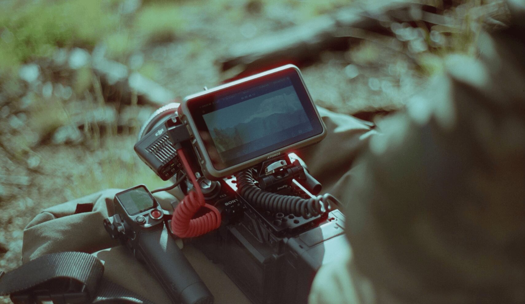 Close-up of a device with a screen mounted on a handlebar outdoors, with blurred natural background.