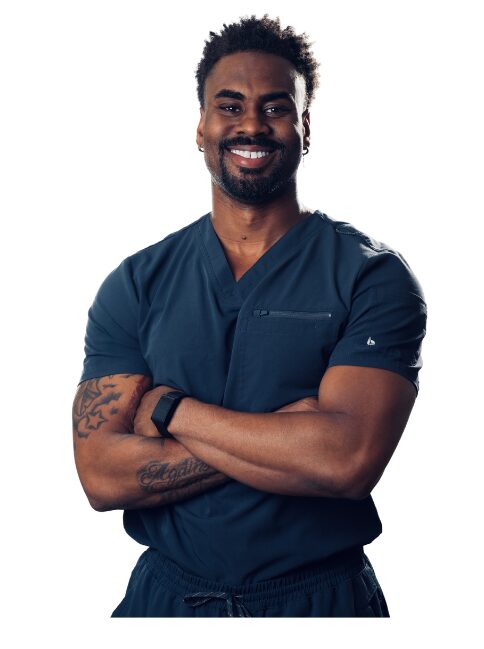 Smiling man with crossed arms wearing navy medical scrubs, standing against a white background.