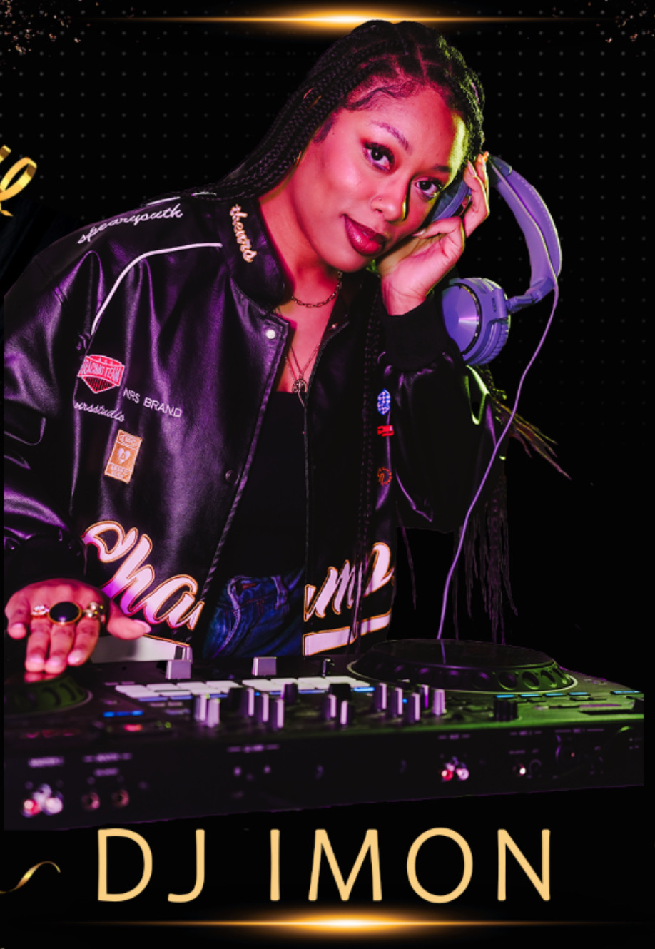 Woman DJ wearing a black jacket with patches, headphones on her neck, standing behind DJ equipment, smiling, with dark background.