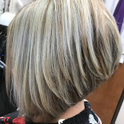 Close-up of a person's short, layered blonde hair with highlights, viewed from the back.